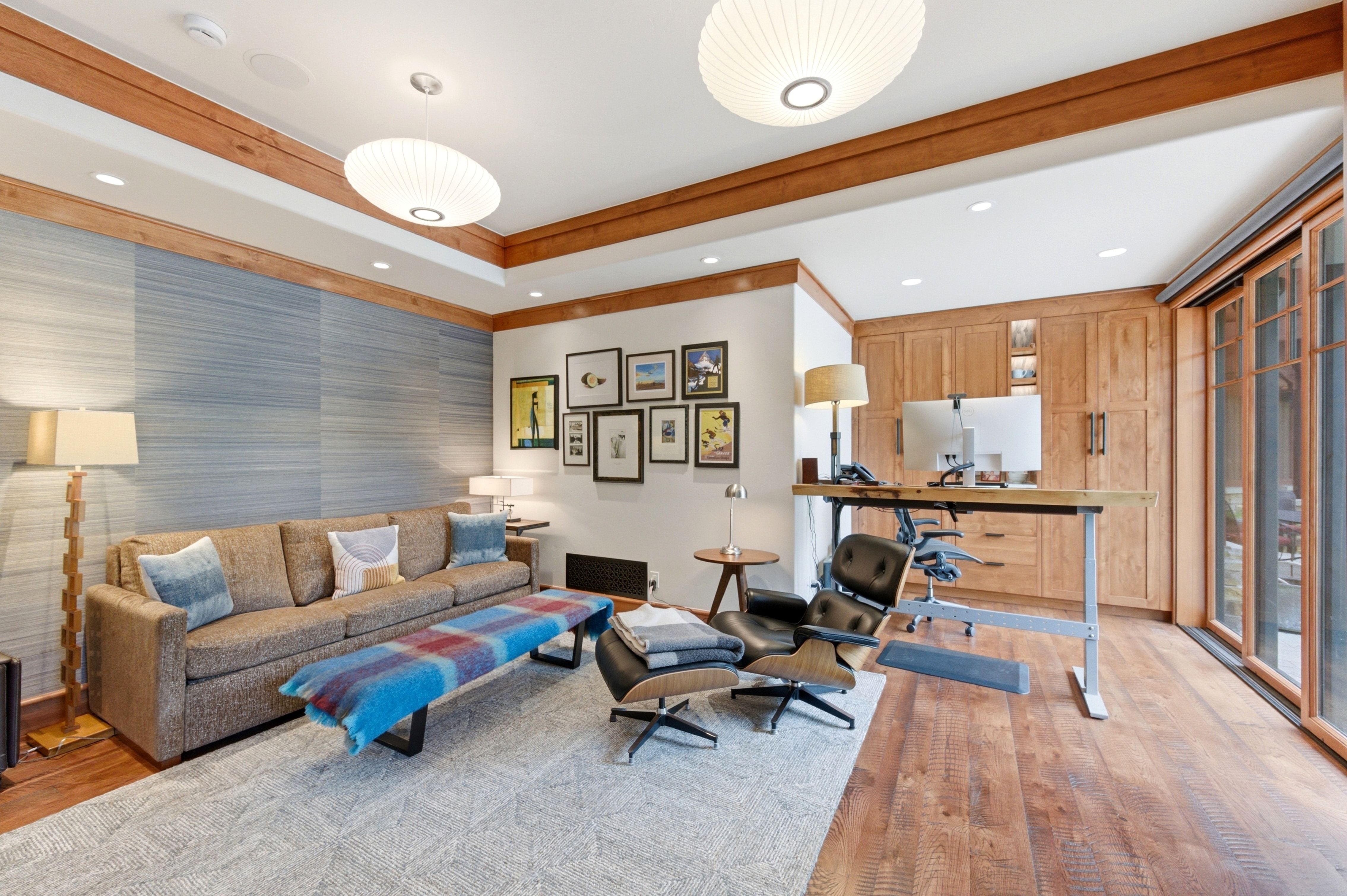 Dedicated office space featuring extensive built-in cabinetry, wood-finish flooring, and a sliding glass door