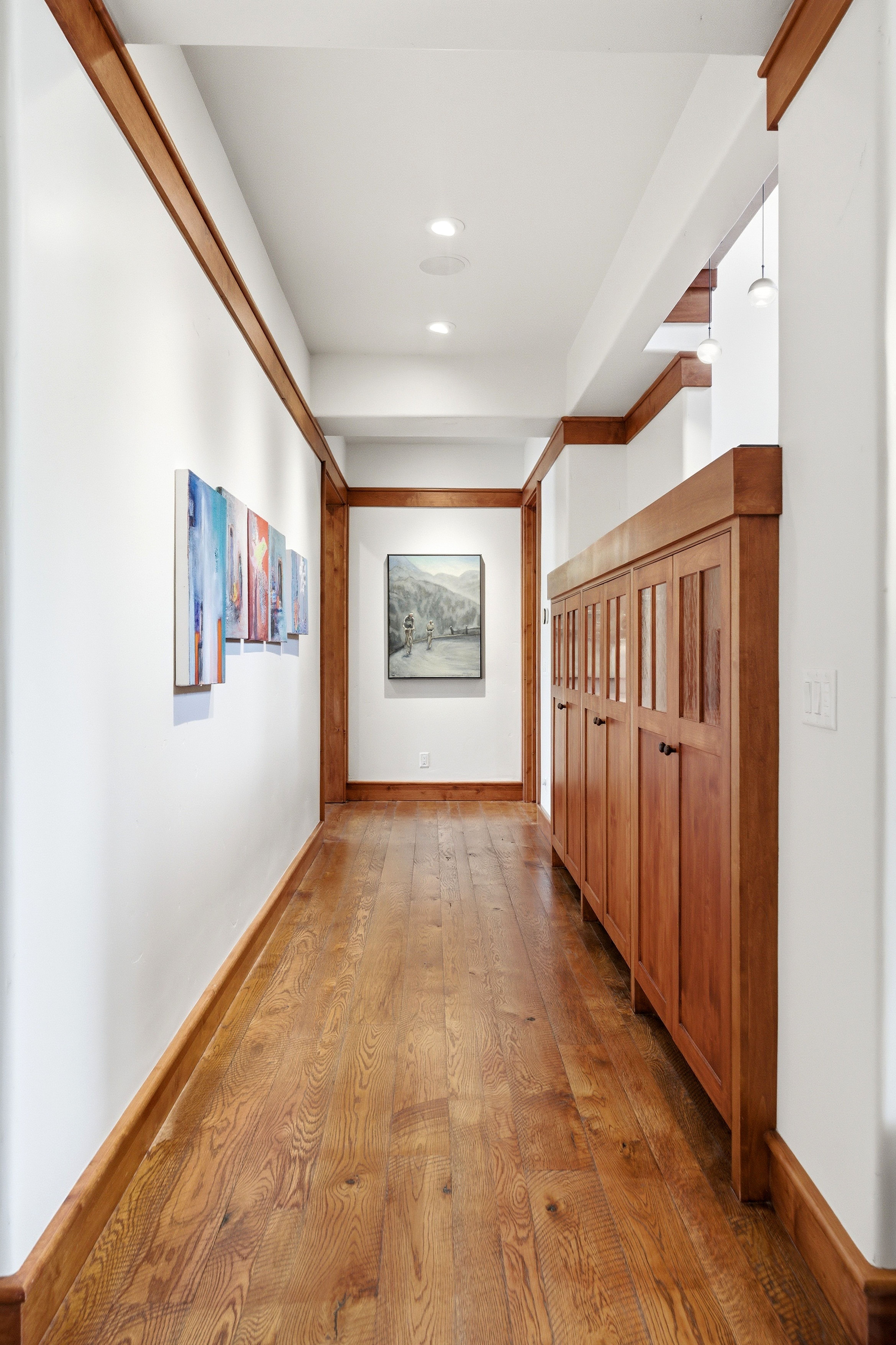 Hallway featuring wood-finish flooring, recessed lighting, and a built-in cabinetry unit