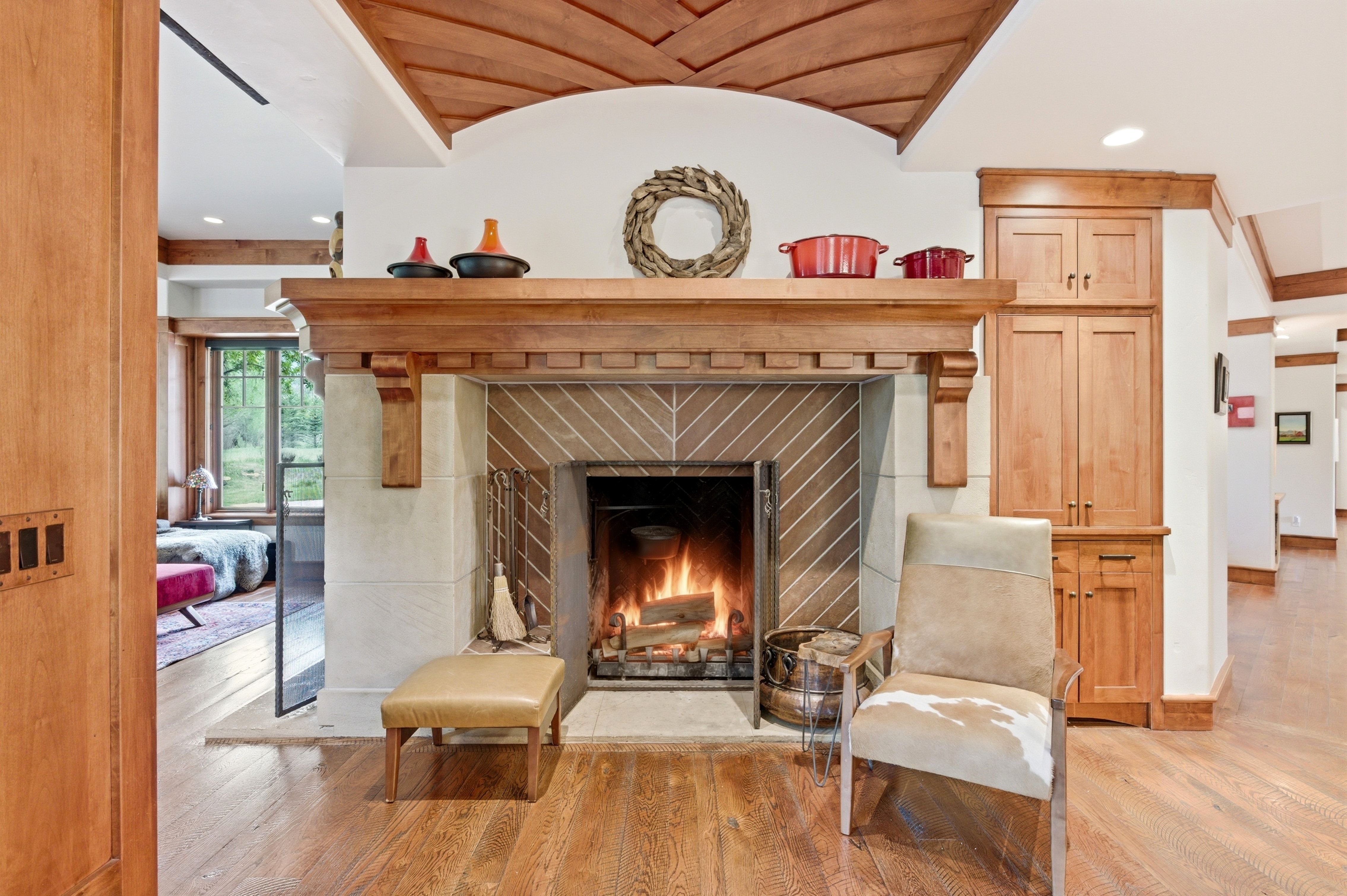 Central fireplace featuring a stone surround with a chevron pattern and a substantial wood mantel