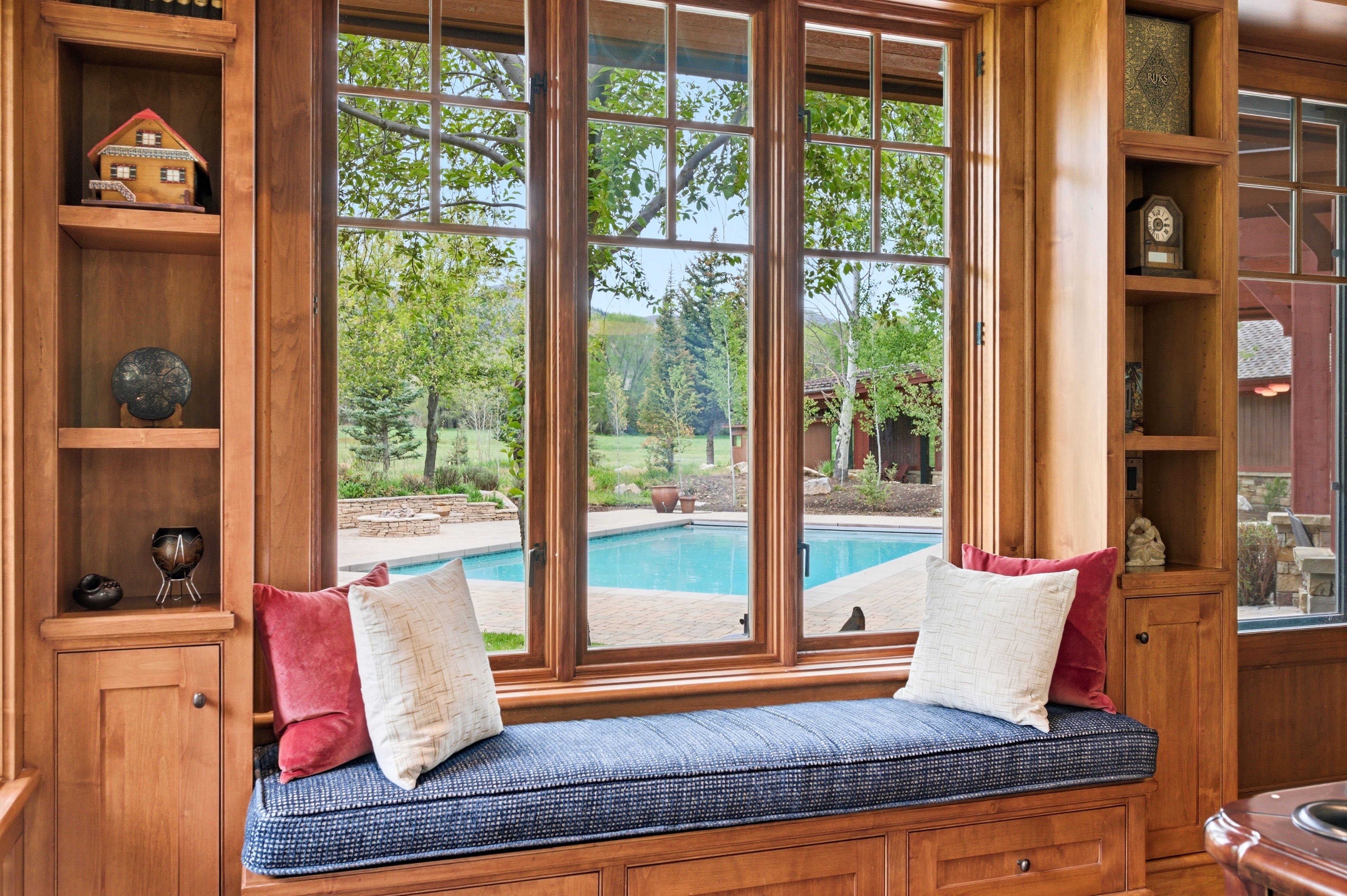 Custom wood-framed window seat with built-in storage and integrated shelving