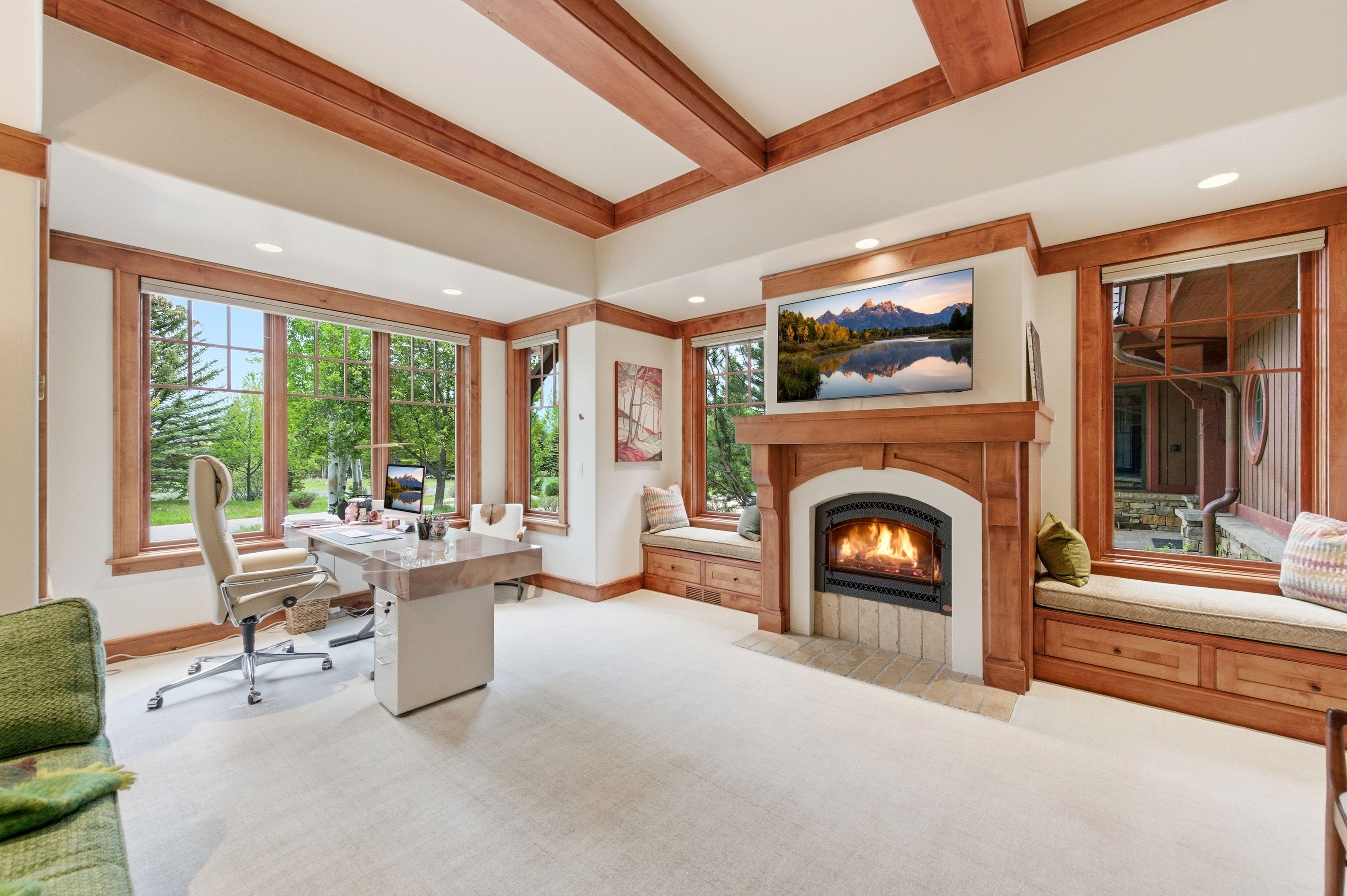 Room featuring a built-in fireplace with a carved wood mantel, exposed wood ceiling beams, recessed lighting, and expansive windows