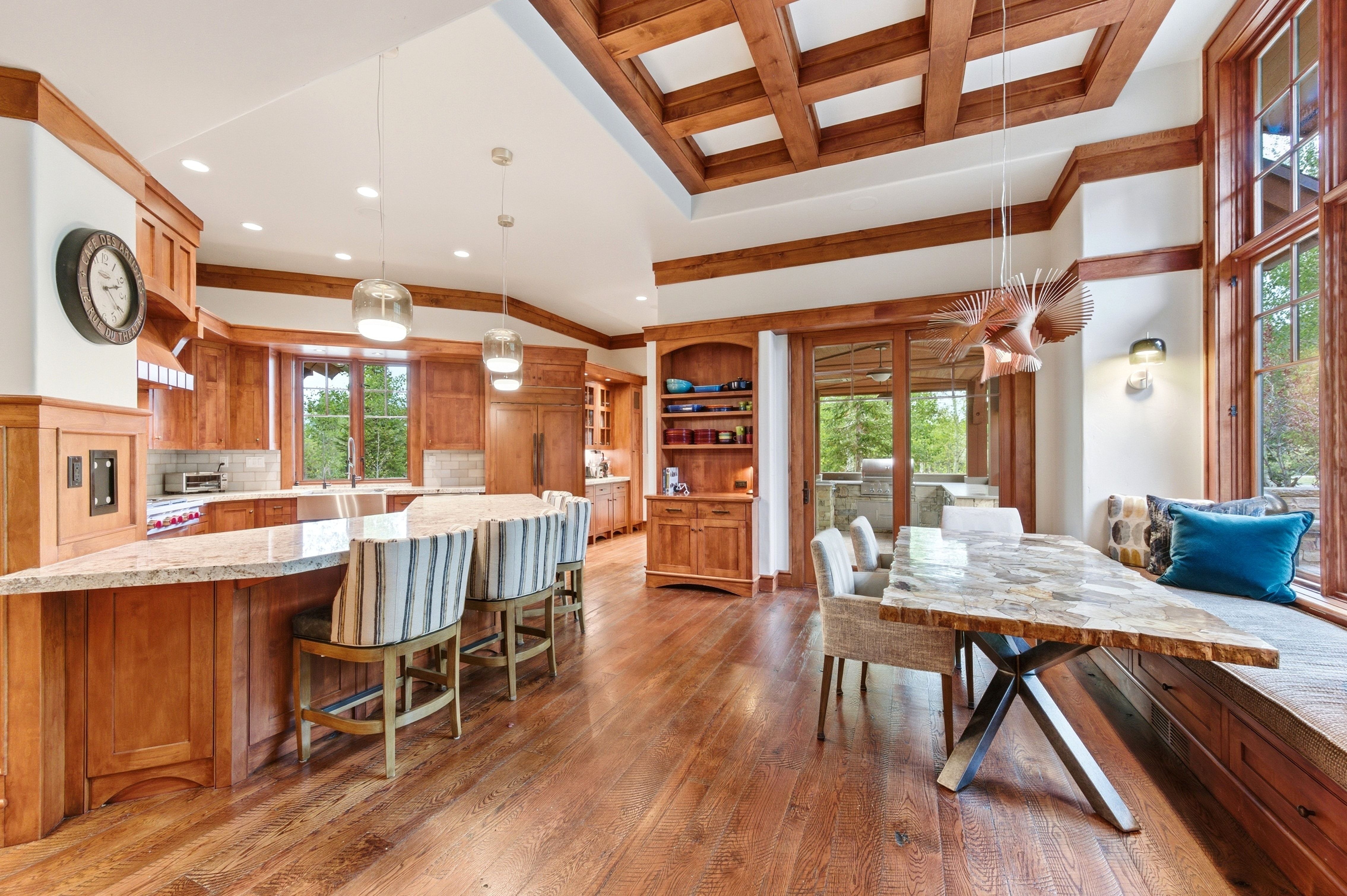 Spacious kitchen and dining area featuring rich wood-finish flooring and cabinetry