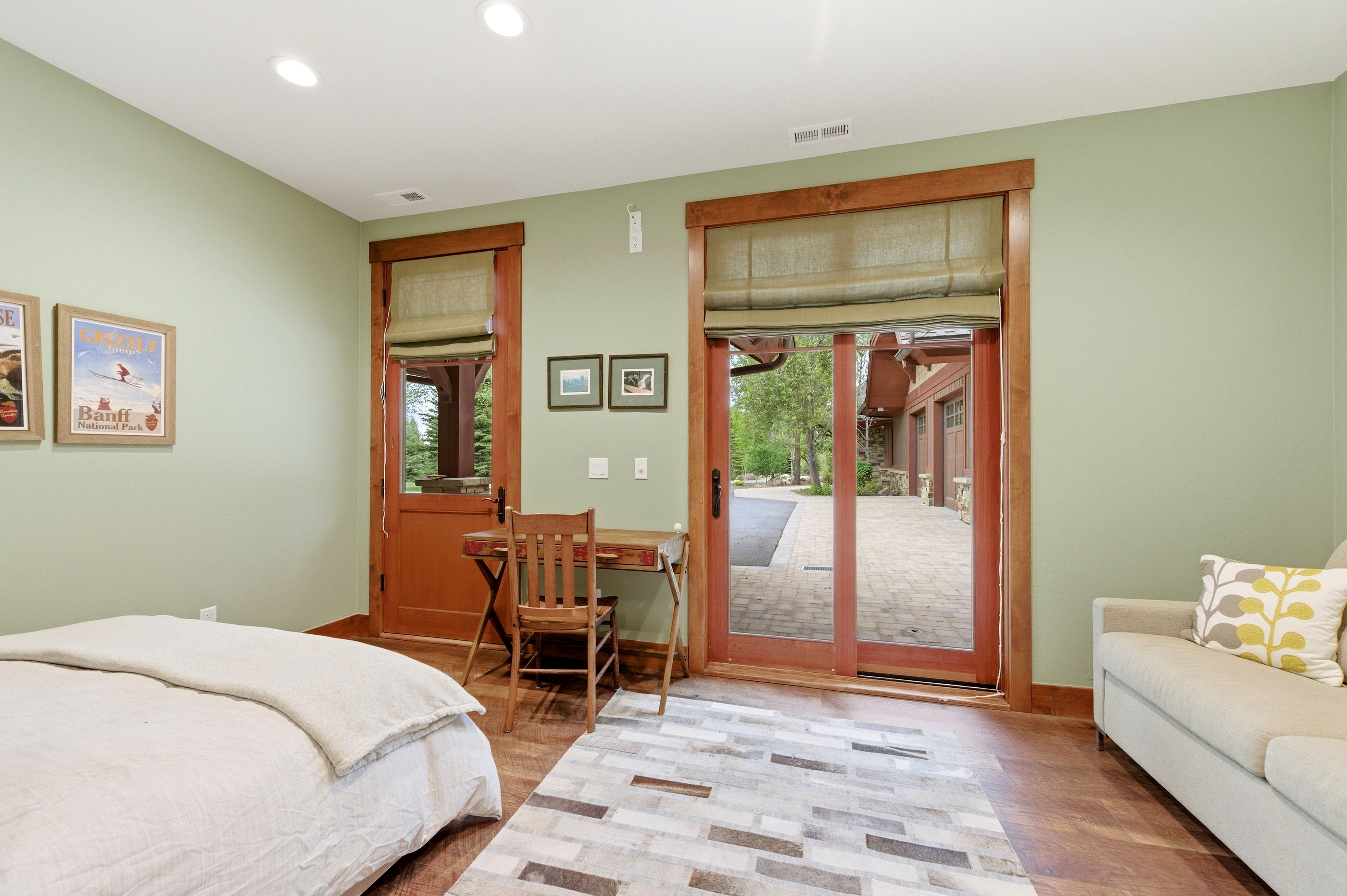 Interior space featuring light green walls, recessed ceiling lighting, and wood-finish flooring