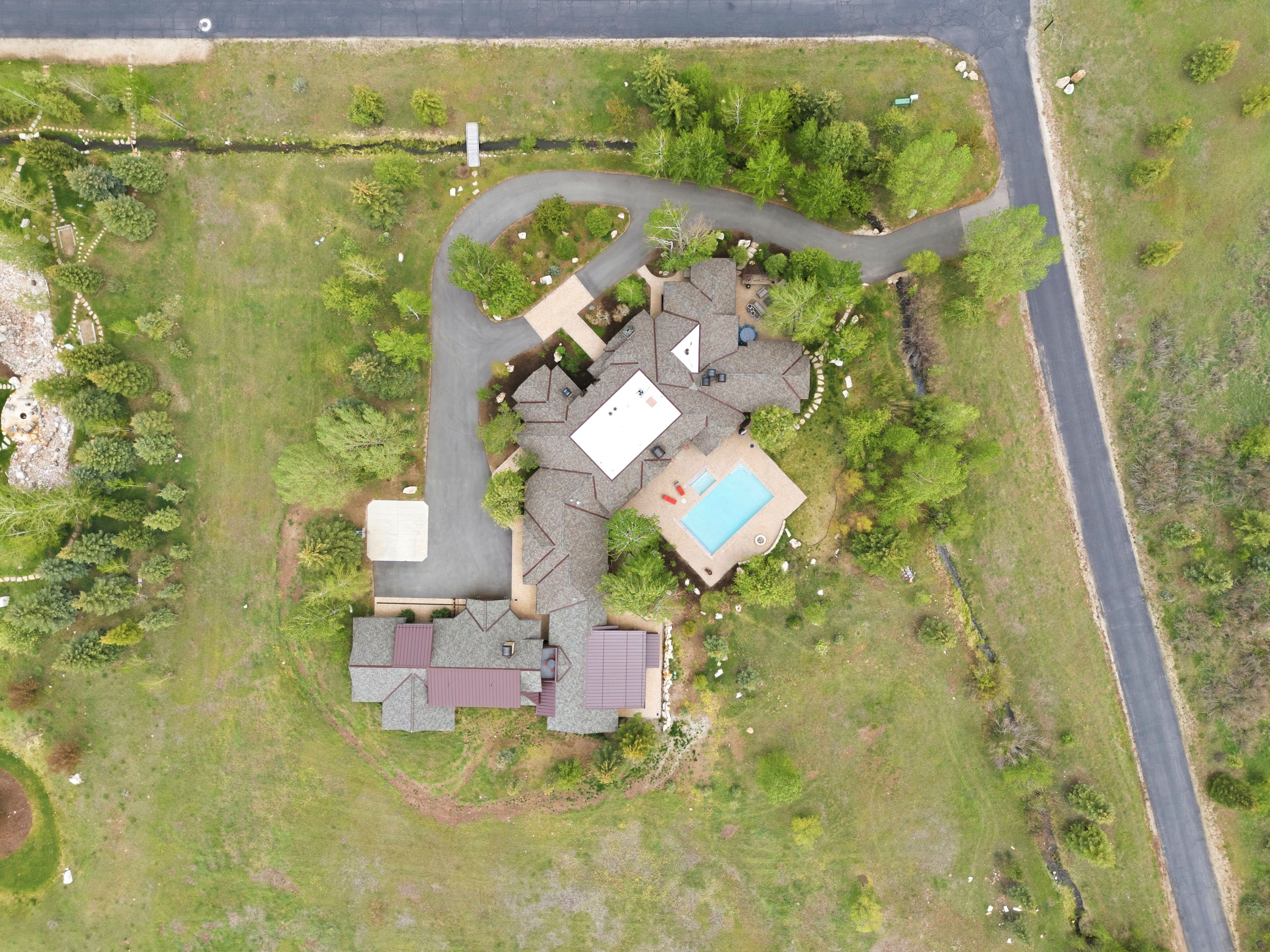 Expansive property featuring a multi-structure residence with a main dwelling, a secondary structure, and a distinct pool area