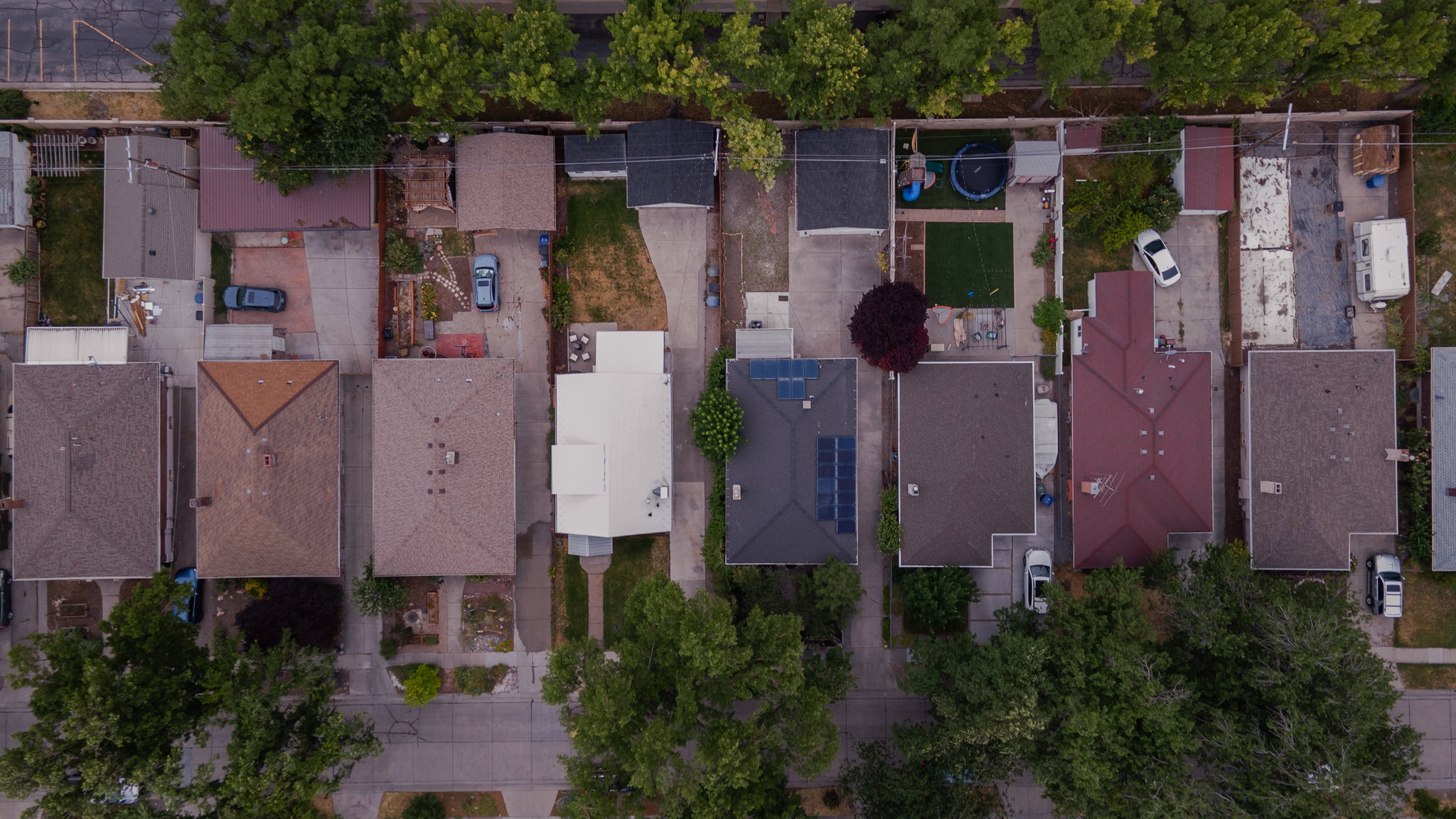 Aerial perspective showcasing multiple properties with varied rooflines and rear yard configurations