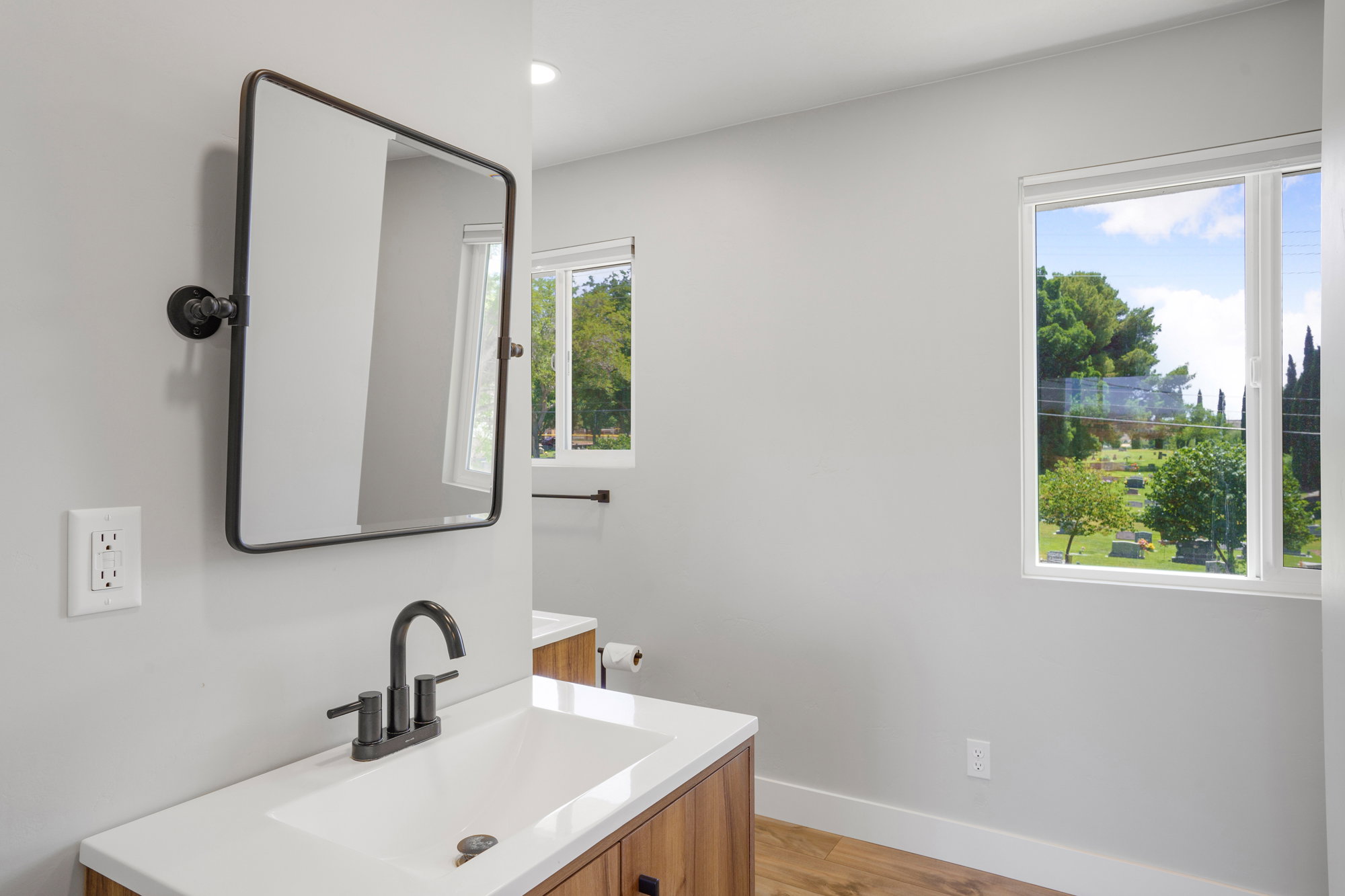 Bathroom featuring a wood-finish vanity with a white countertop and a rectangular sink