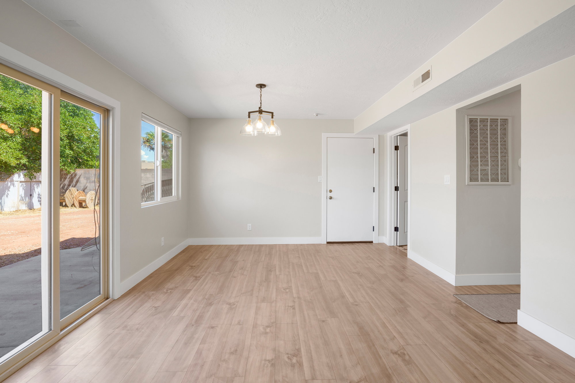 Spacious interior with wood-finish flooring, light-toned walls, and white trim