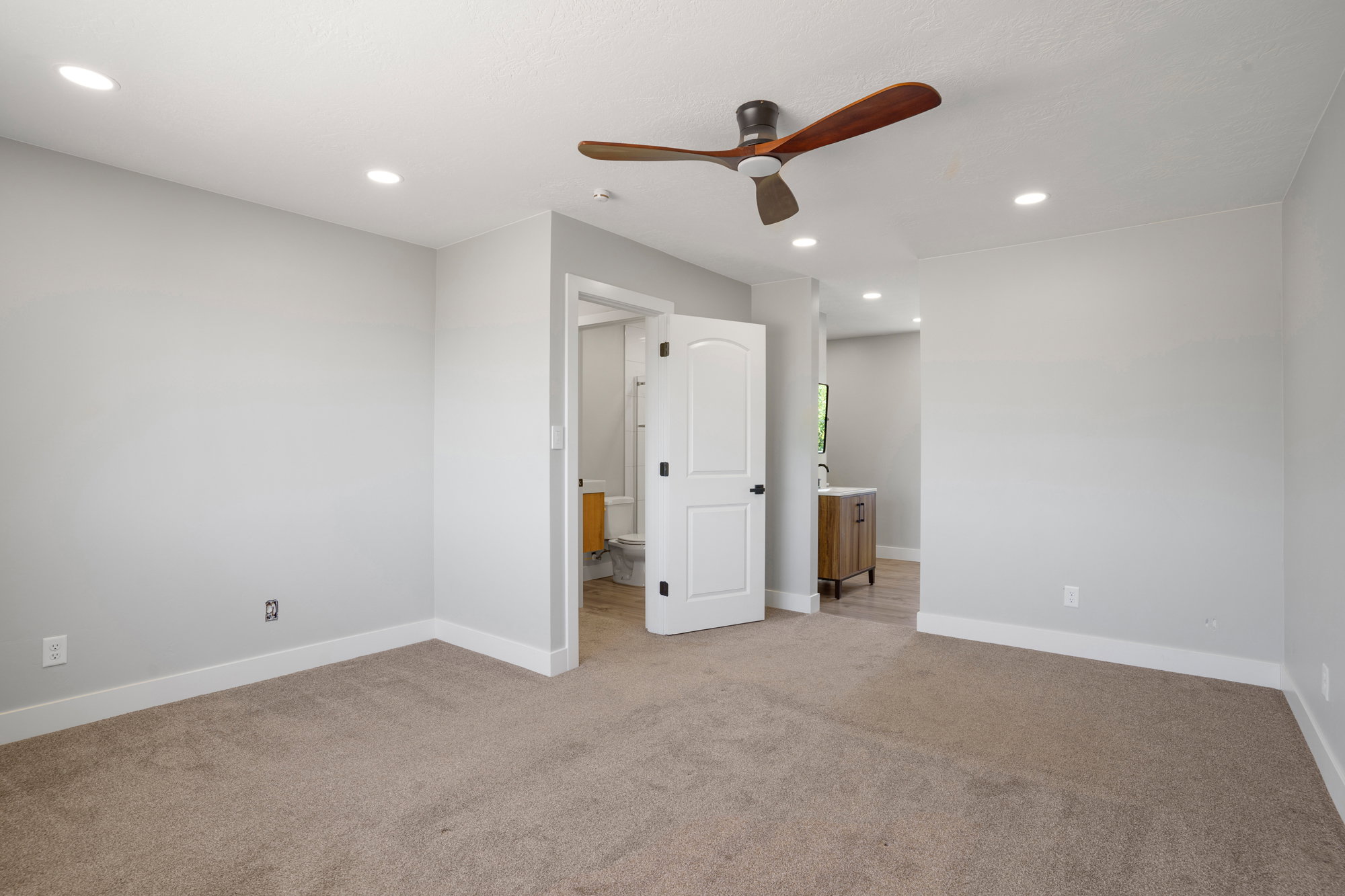 Carpeted room with recessed lighting and a ceiling fan with wood-finish blades
