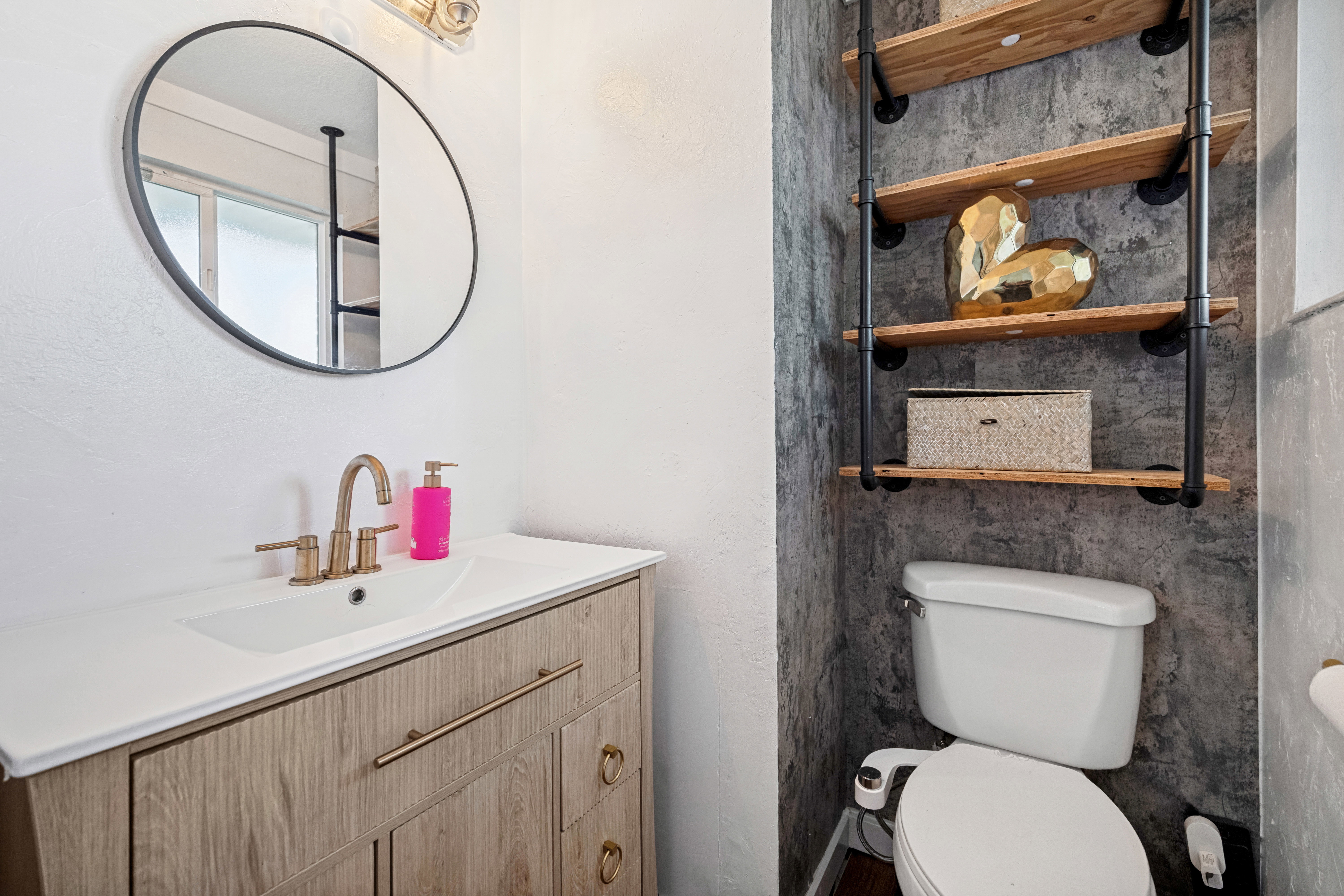 Bathroom vanity with a white countertop and integrated sink, featuring a brass-finish faucet