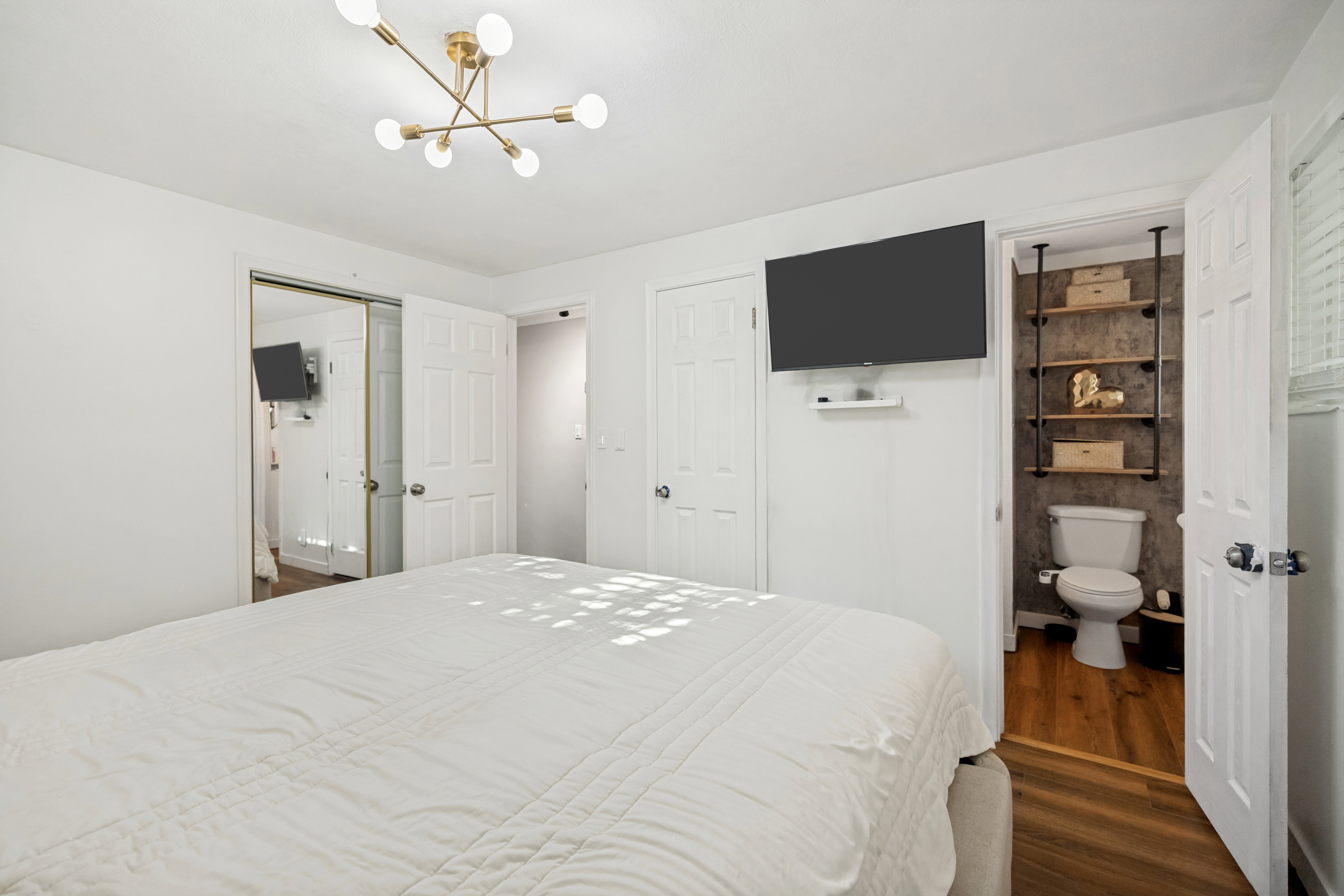 Bright bedroom featuring a contemporary brass chandelier