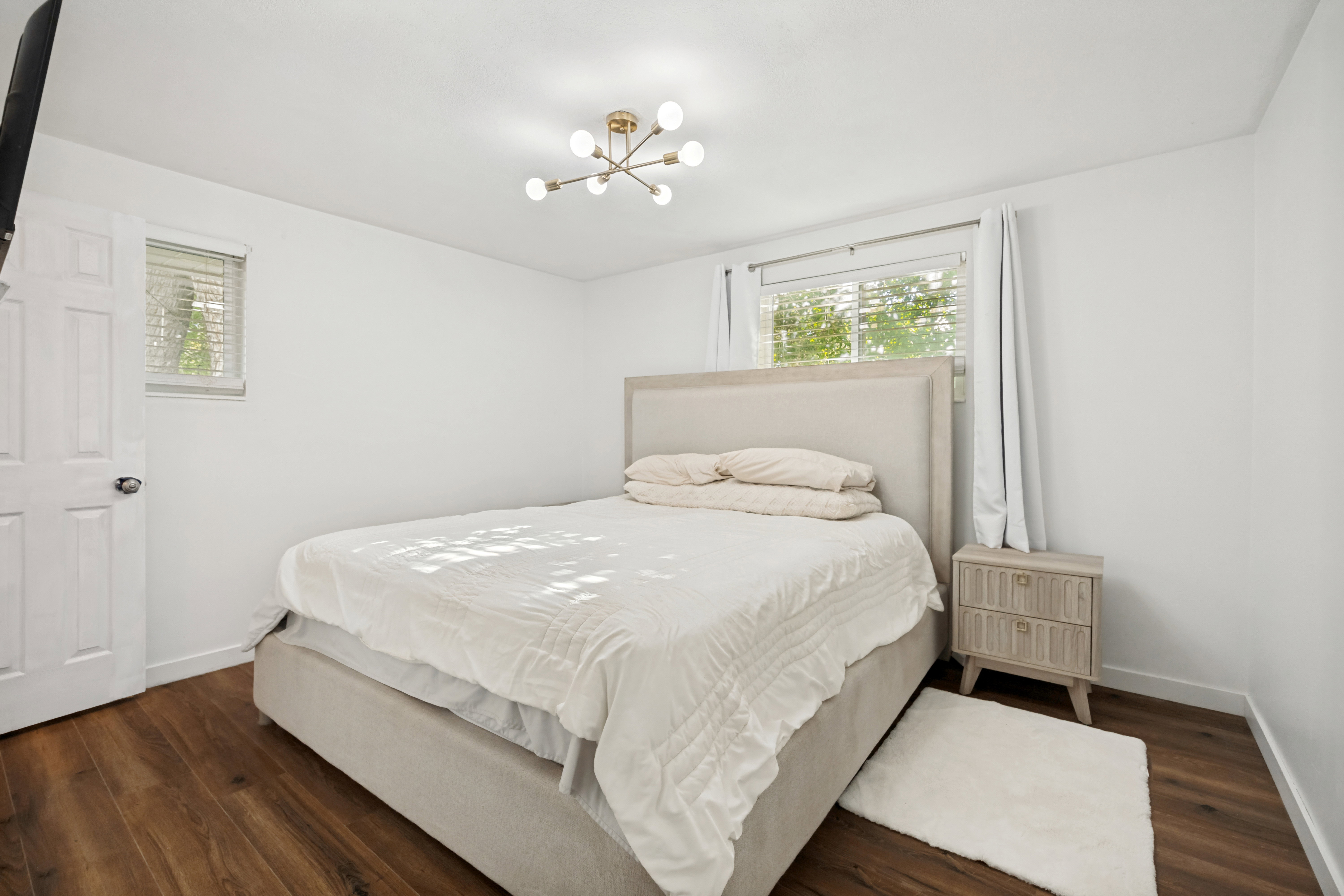 Hardwood-style flooring throughout this room, featuring a modern ceiling light fixture