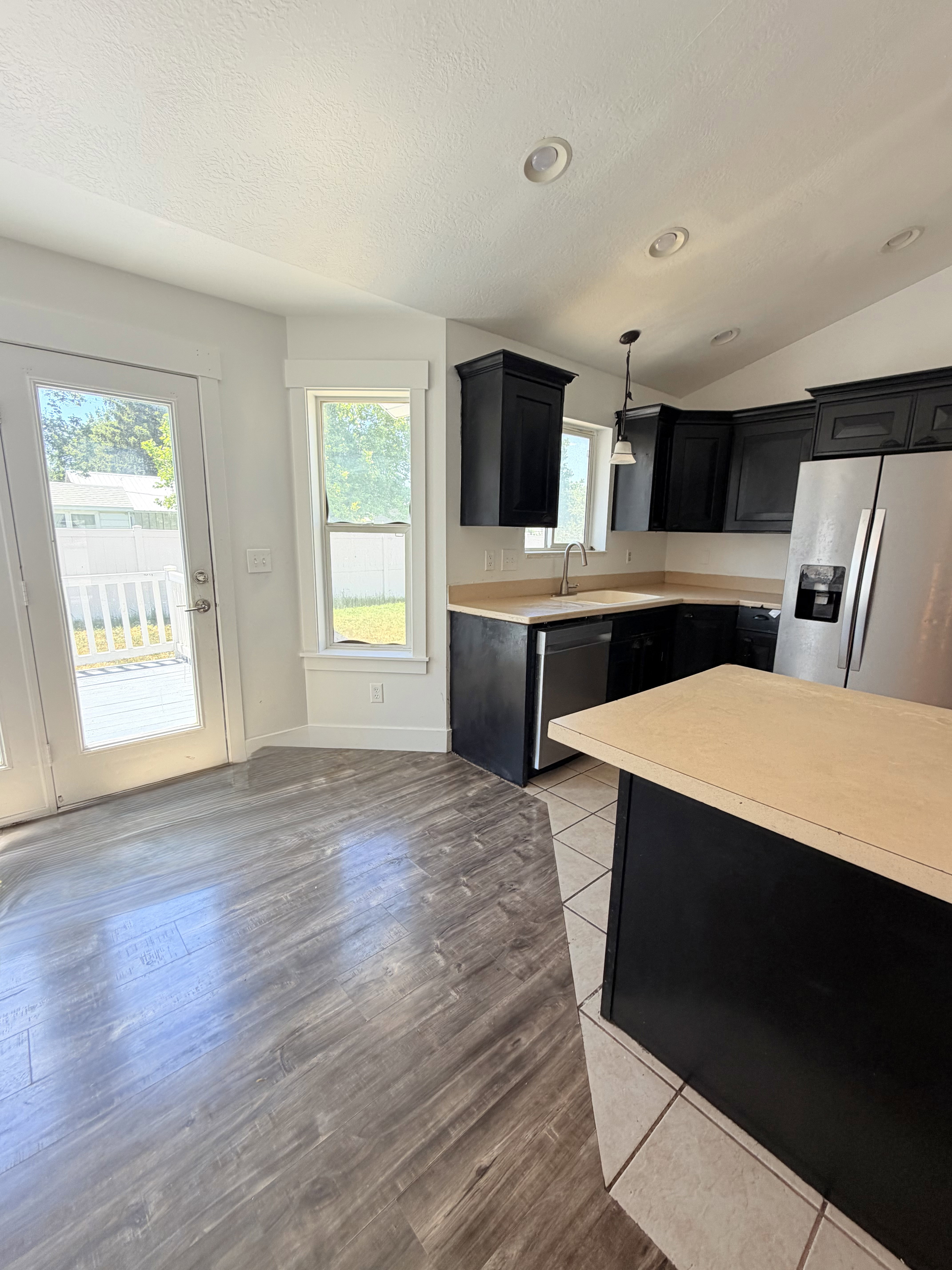 Kitchen featuring dark cabinetry, stainless steel appliances, and light wood-finish countertops