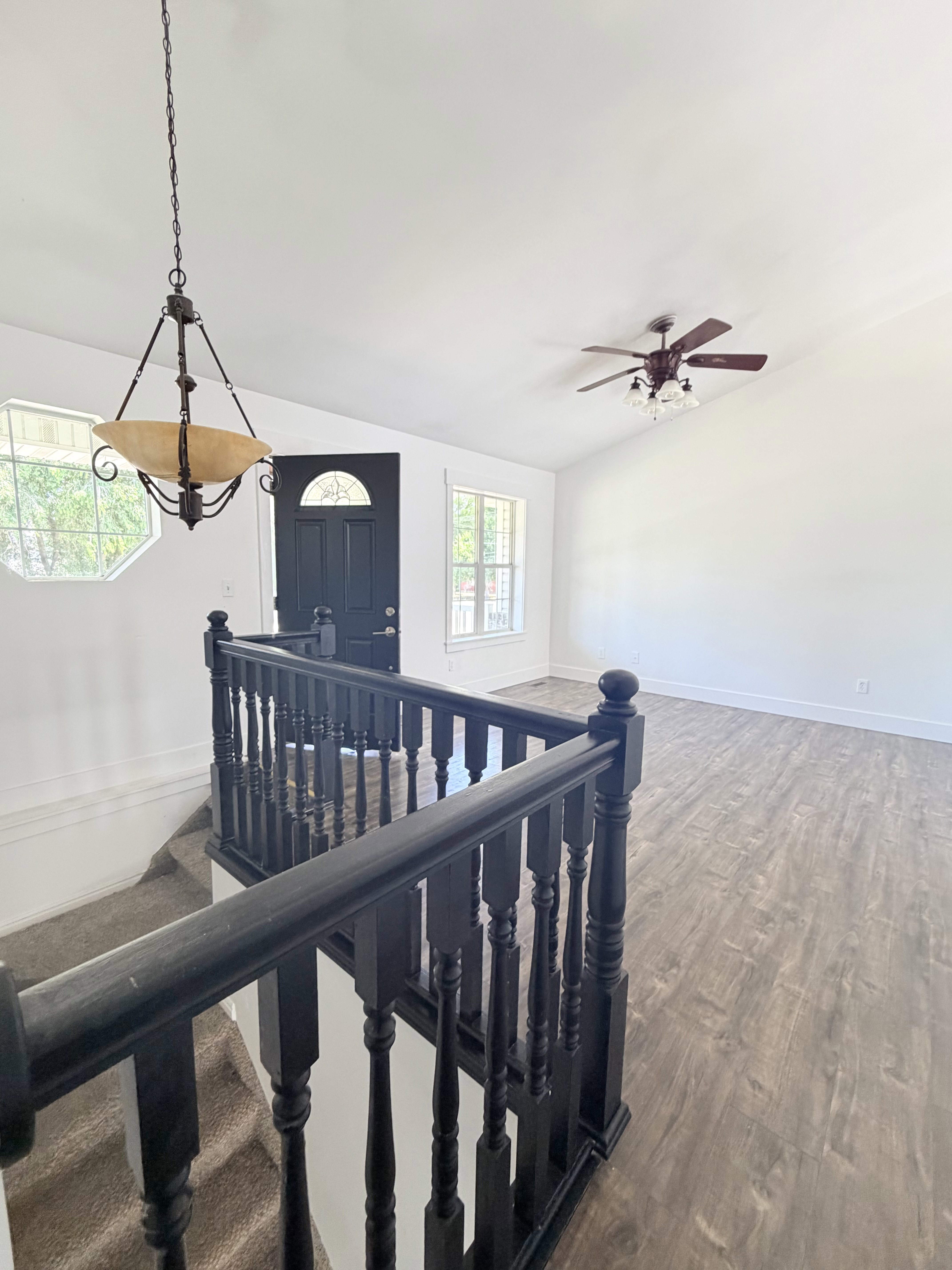 Split-level entry featuring dark wood-finish staircase railing and carpeted stairs