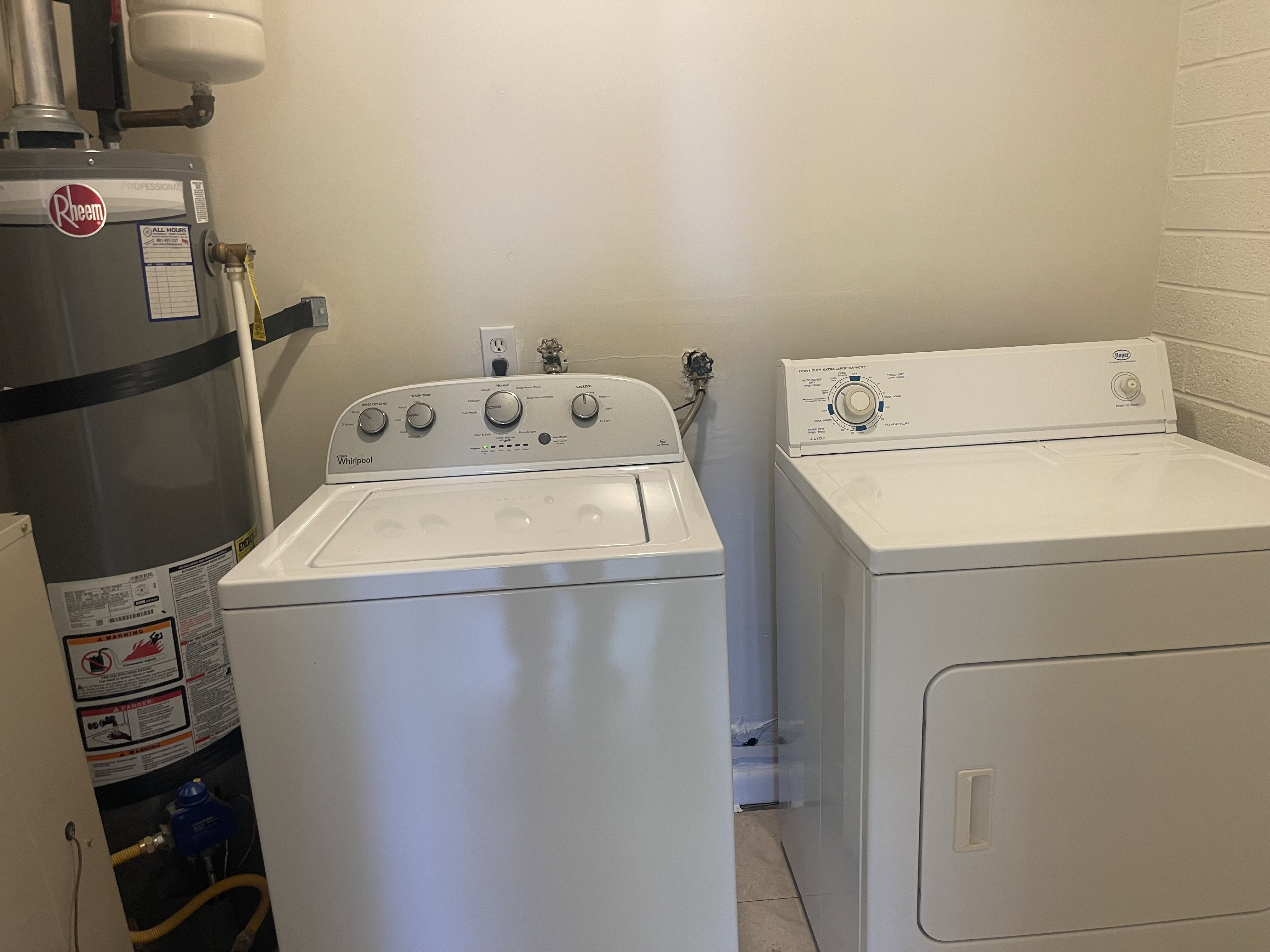 Dedicated utility area featuring a water heater, washer, and dryer connections