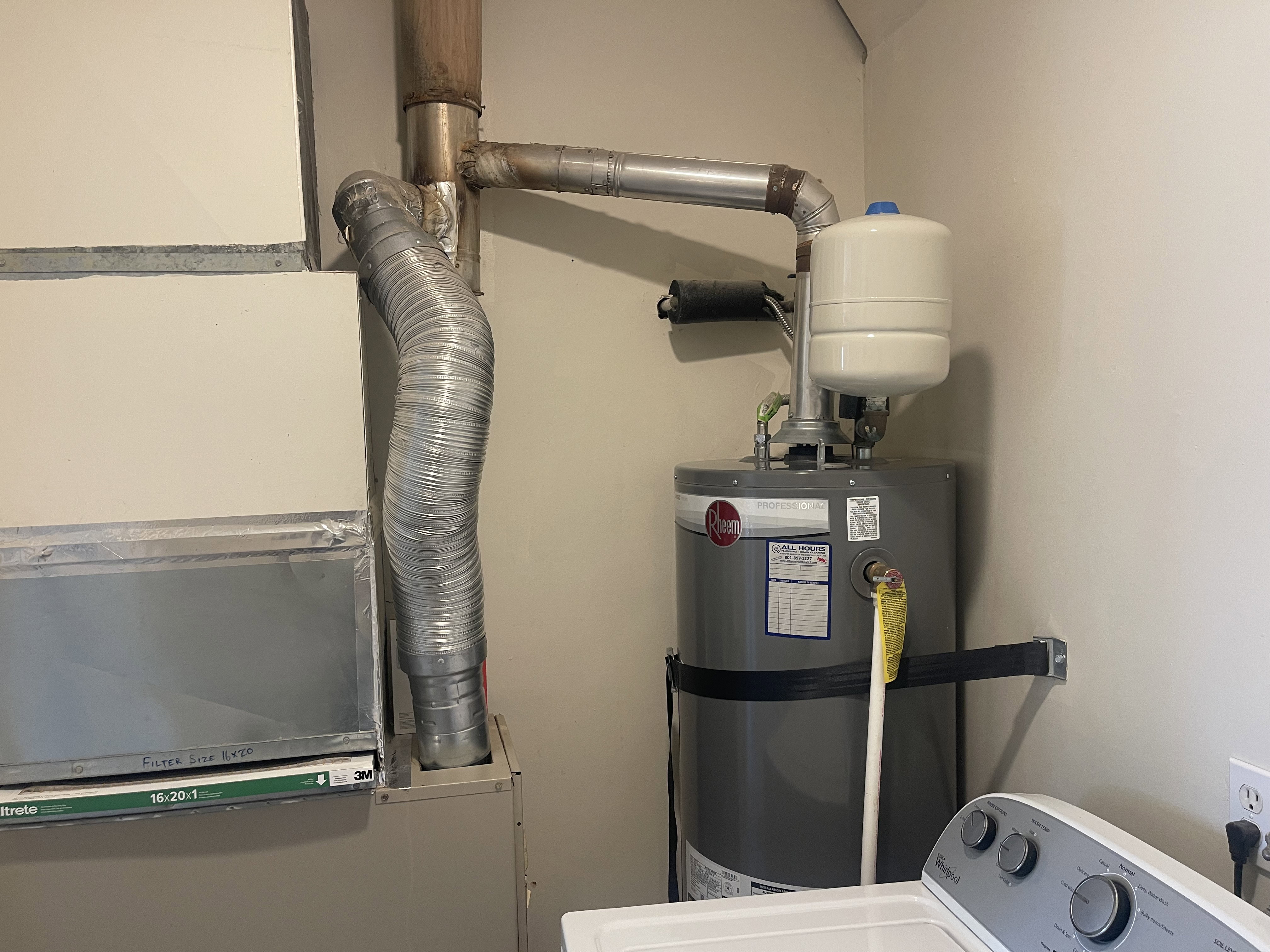 Utility area featuring a water heater, expansion tank, HVAC system, and electrical outlet