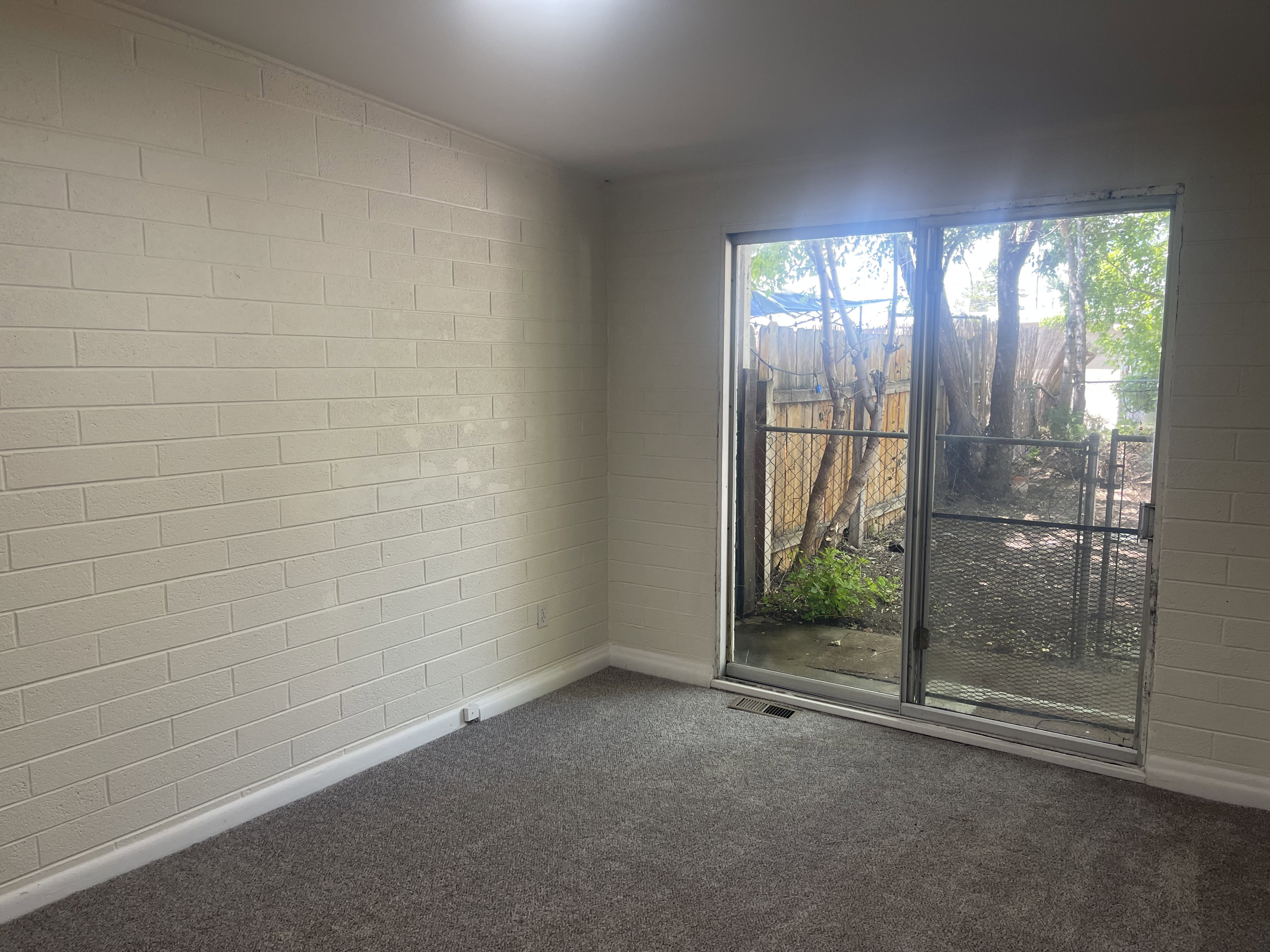 Sliding glass door opening to an outdoor area with mature trees