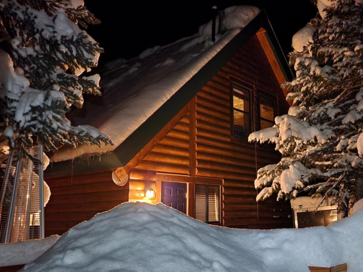 Log cabin exterior featuring a prominent A-frame roofline and horizontal log siding
