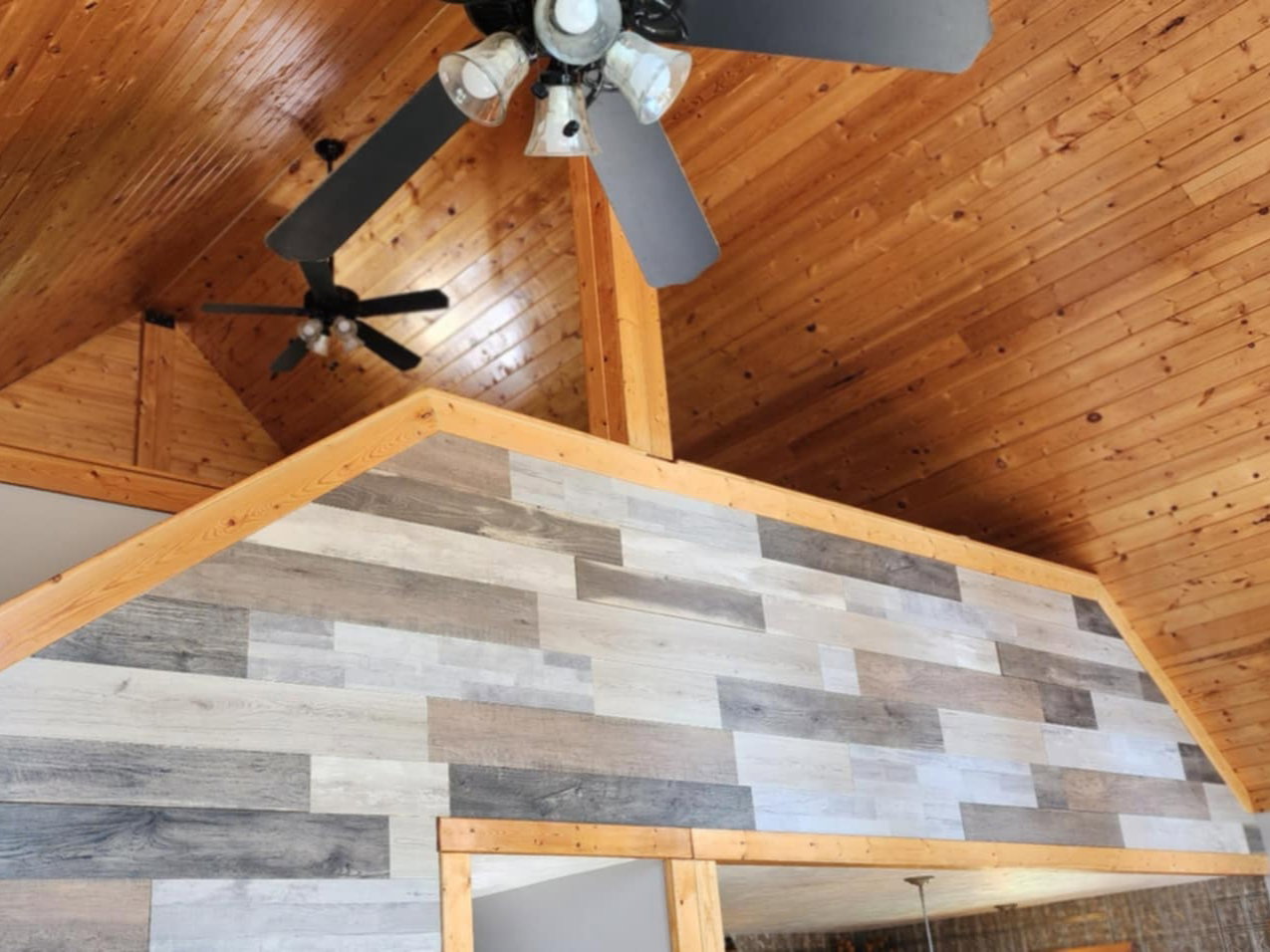 Vaulted wood-paneled ceilings featuring multiple ceiling fans