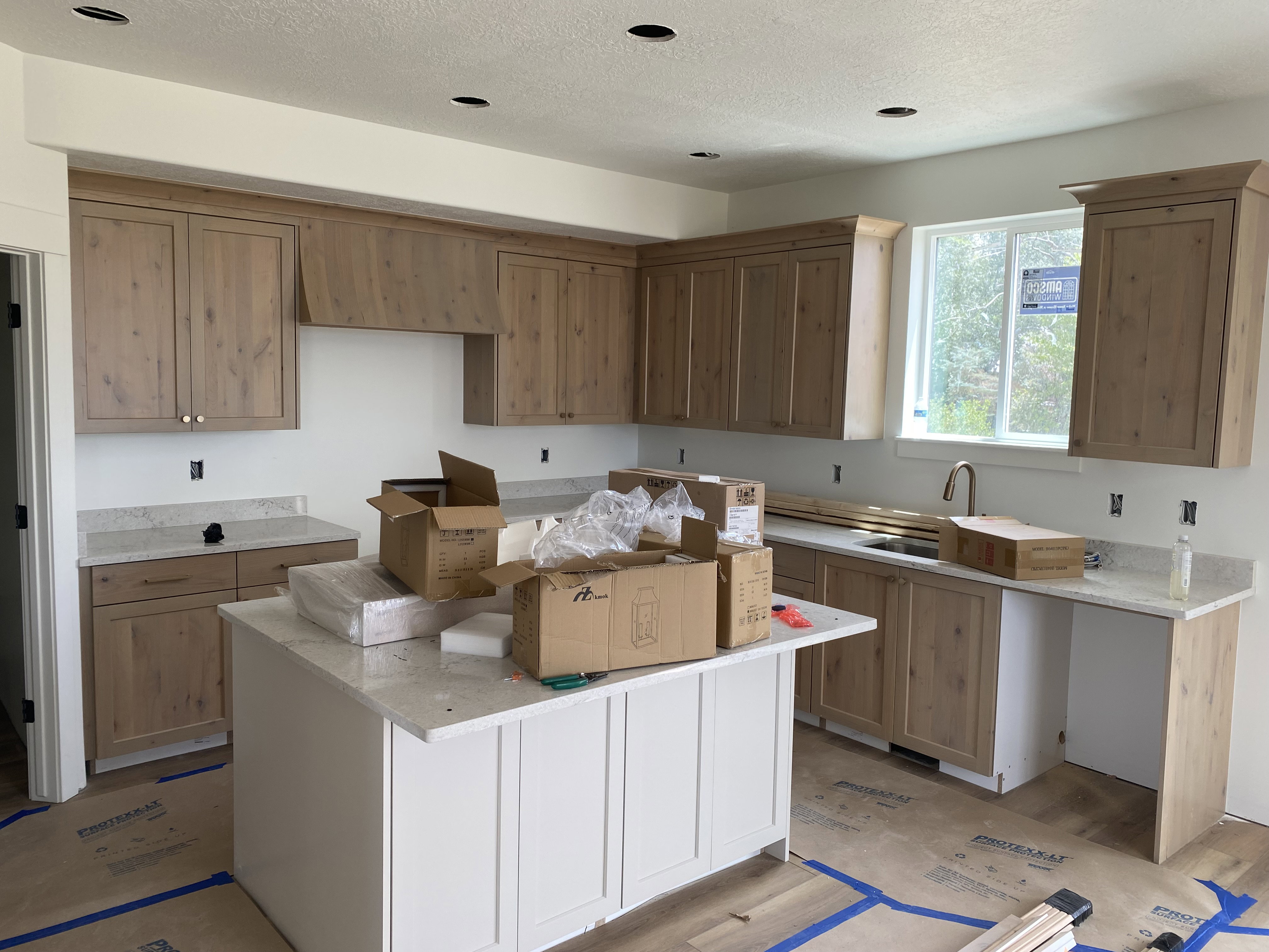 Kitchen featuring wood-finish cabinetry, light-toned countertops, and a central island