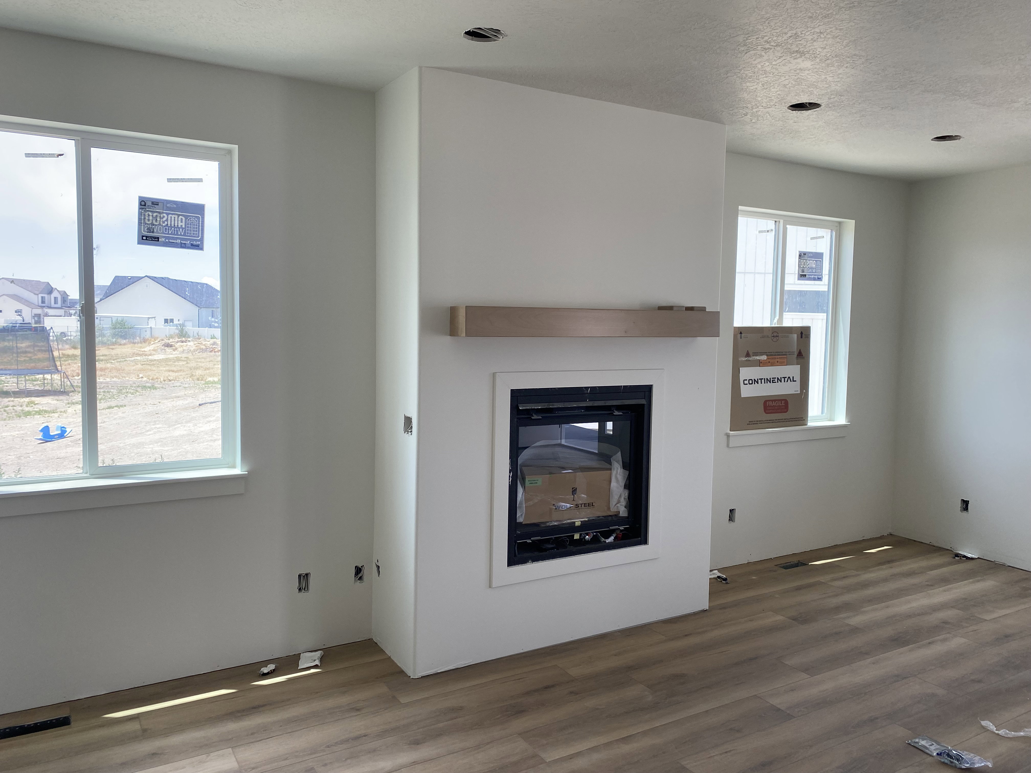 Fireplace with a light wood-finish mantel and a white surround