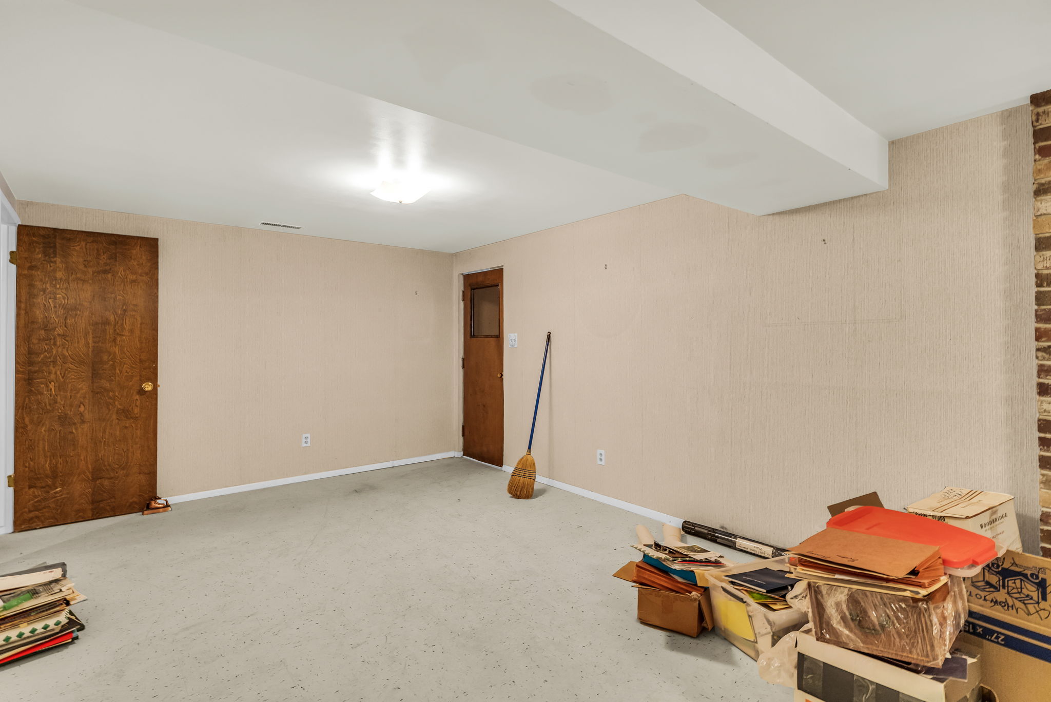 Spacious room with light-colored walls and carpeted flooring