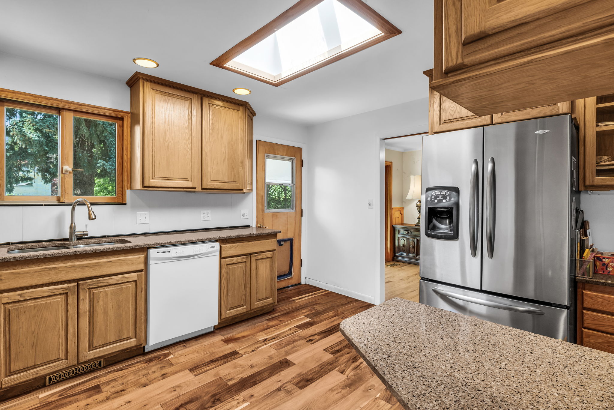 Kitchen featuring wood-finish flooring, recessed lighting, and a prominent skylight