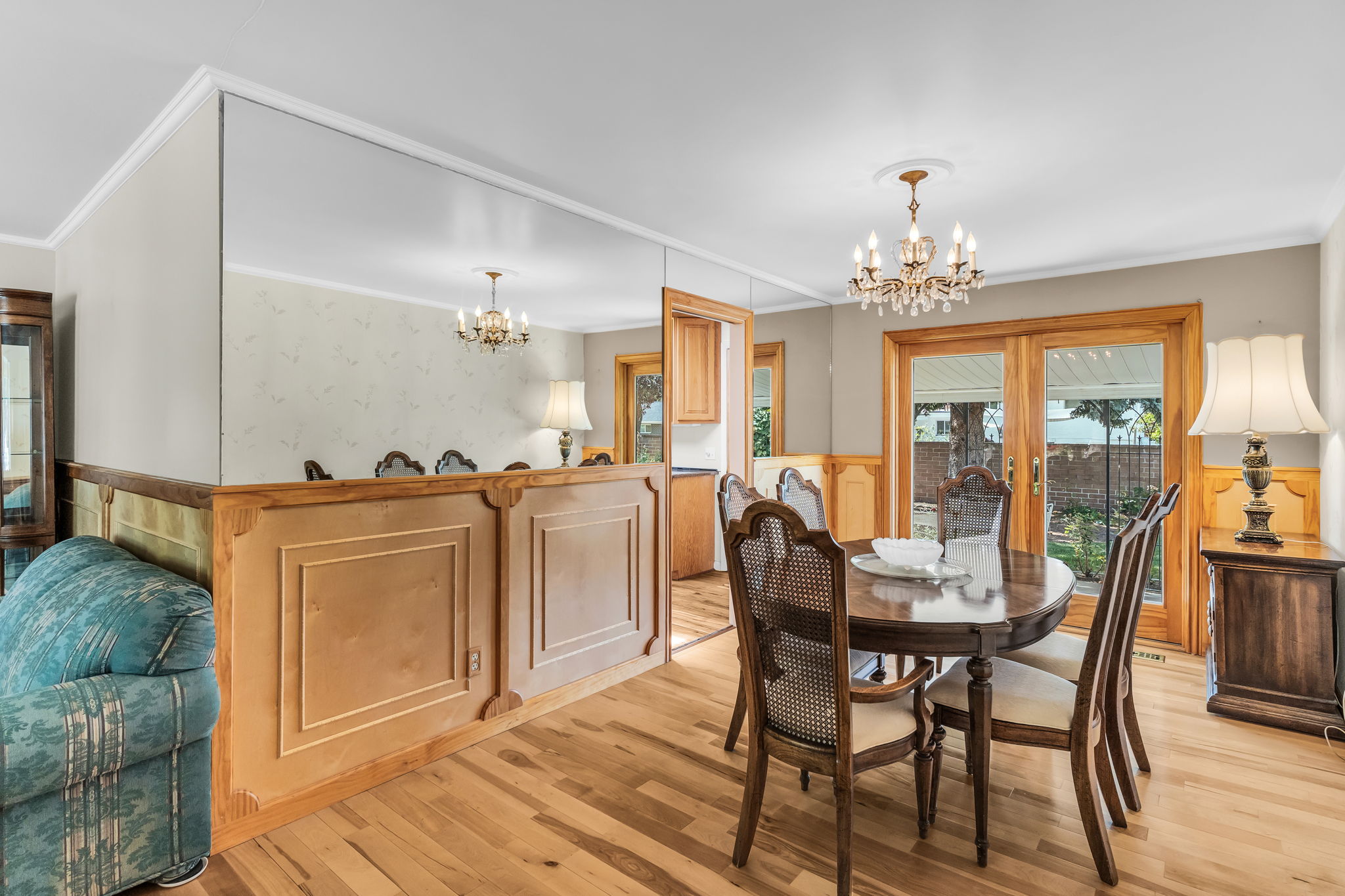 Dining area featuring wood-finish flooring, a crystal chandelier, and natural wood trim throughout