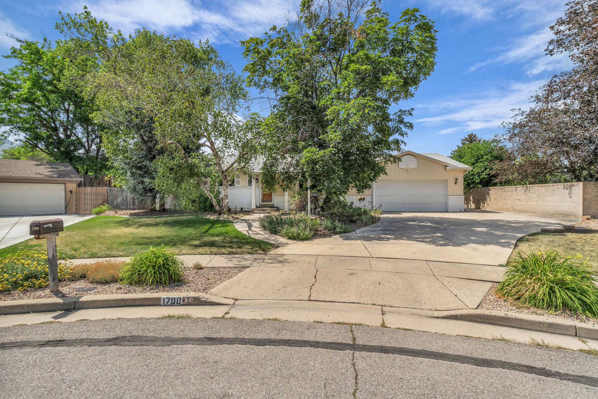 Cream exterior with white trim, featuring a two-car garage