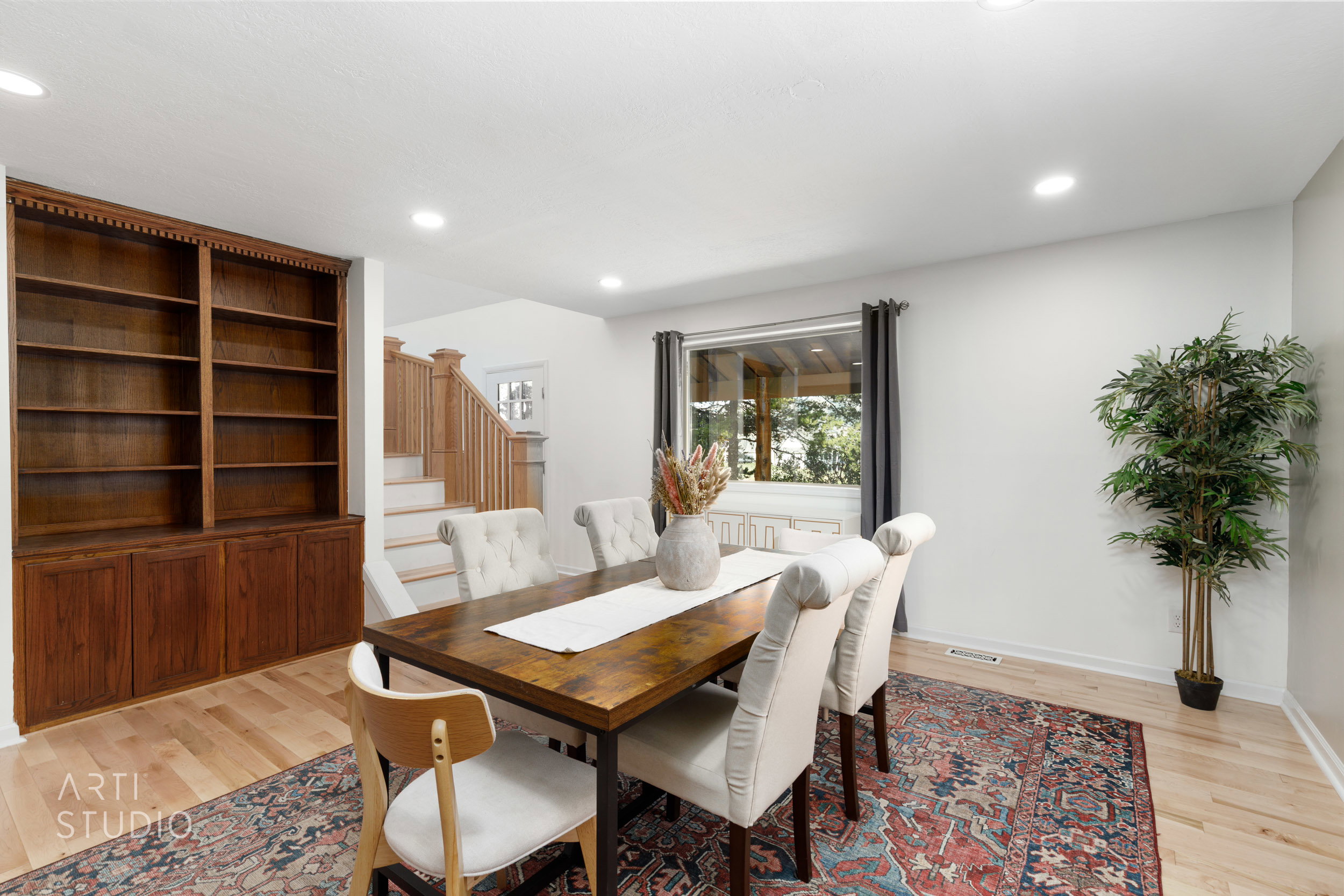 Dining area featuring wood-finish flooring, recessed lighting, and a built-in wood bookshelf with lower cabinetry
