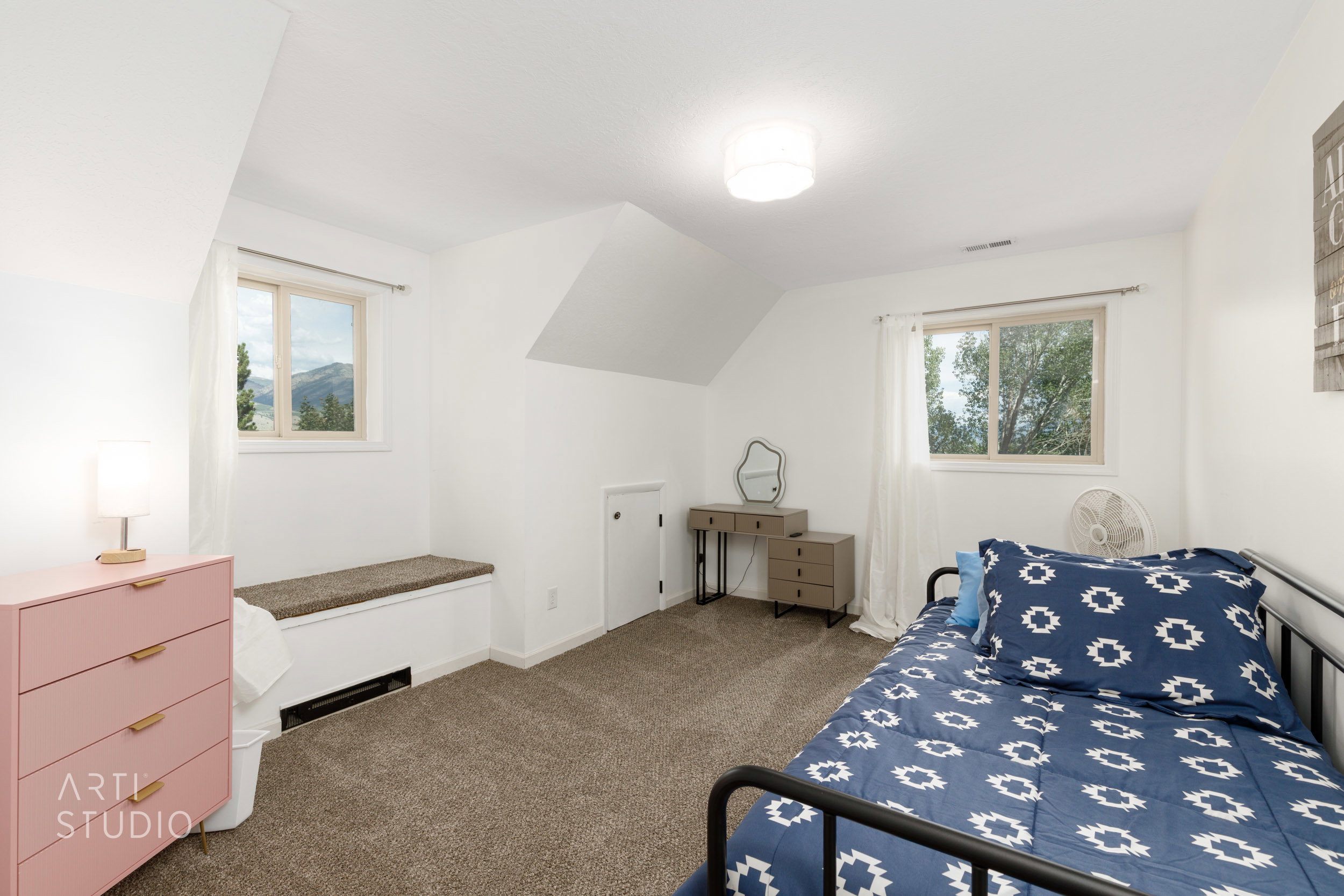 Carpeted bedroom with white walls and sloped ceilings