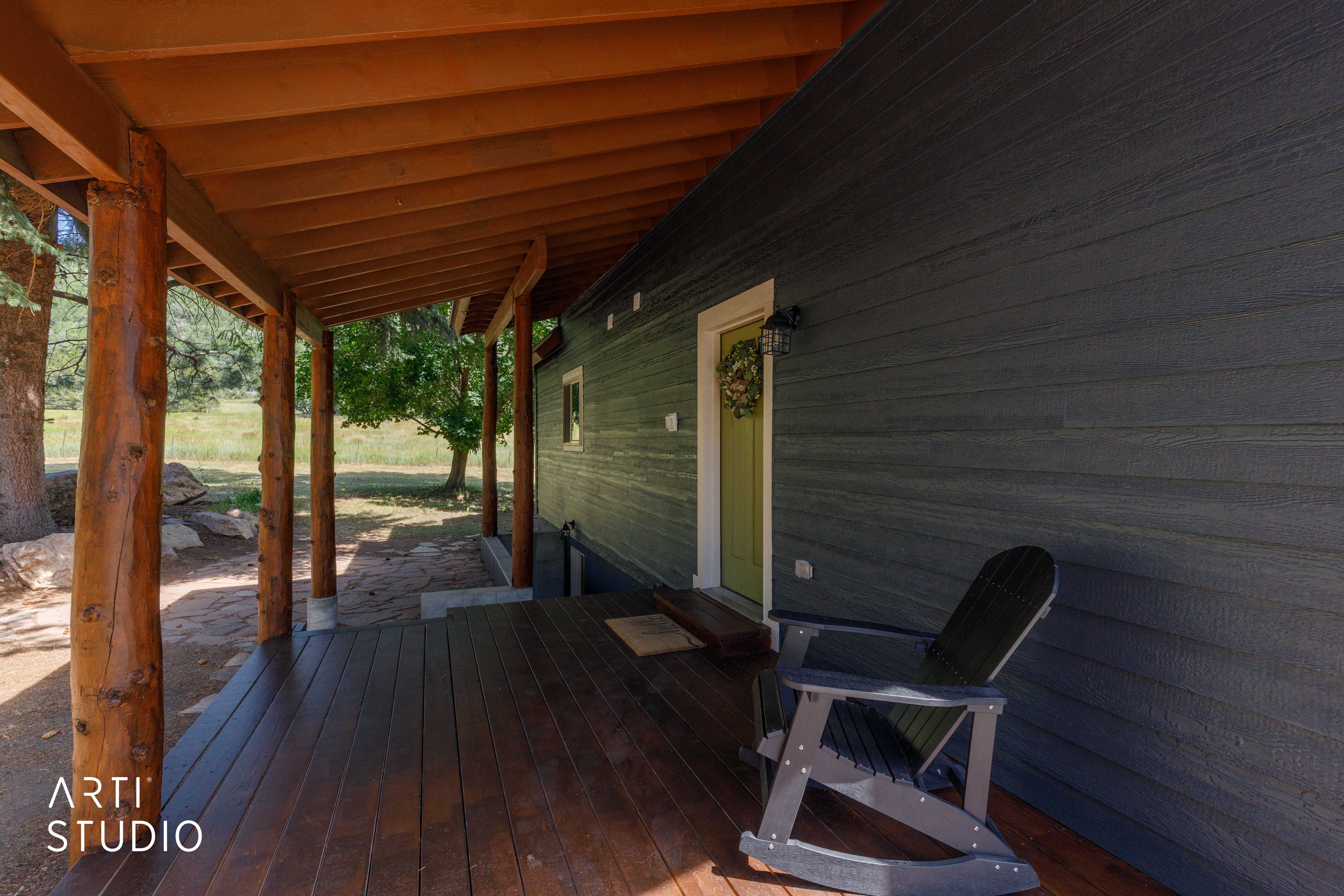 Inviting covered porch featuring natural wood posts and a rich wood-finish deck