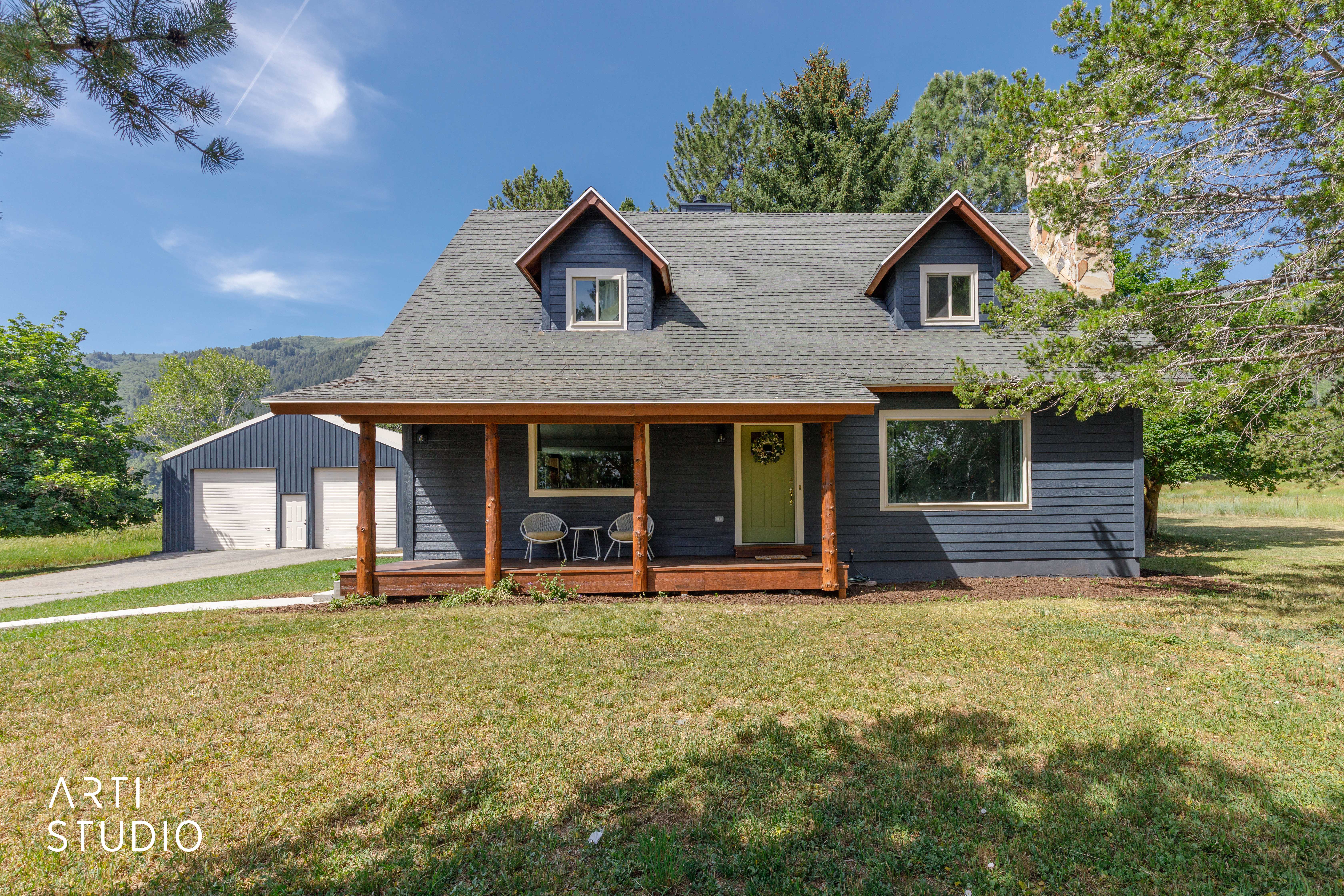 Blue siding facade with a covered porch featuring natural wood posts