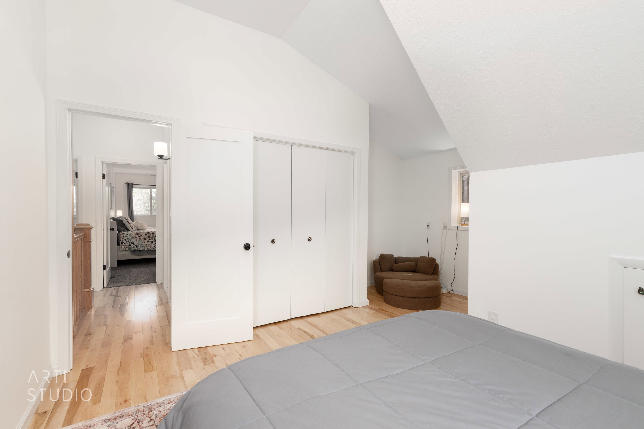 Hardwood-style flooring throughout, featuring a vaulted ceiling and bright white walls