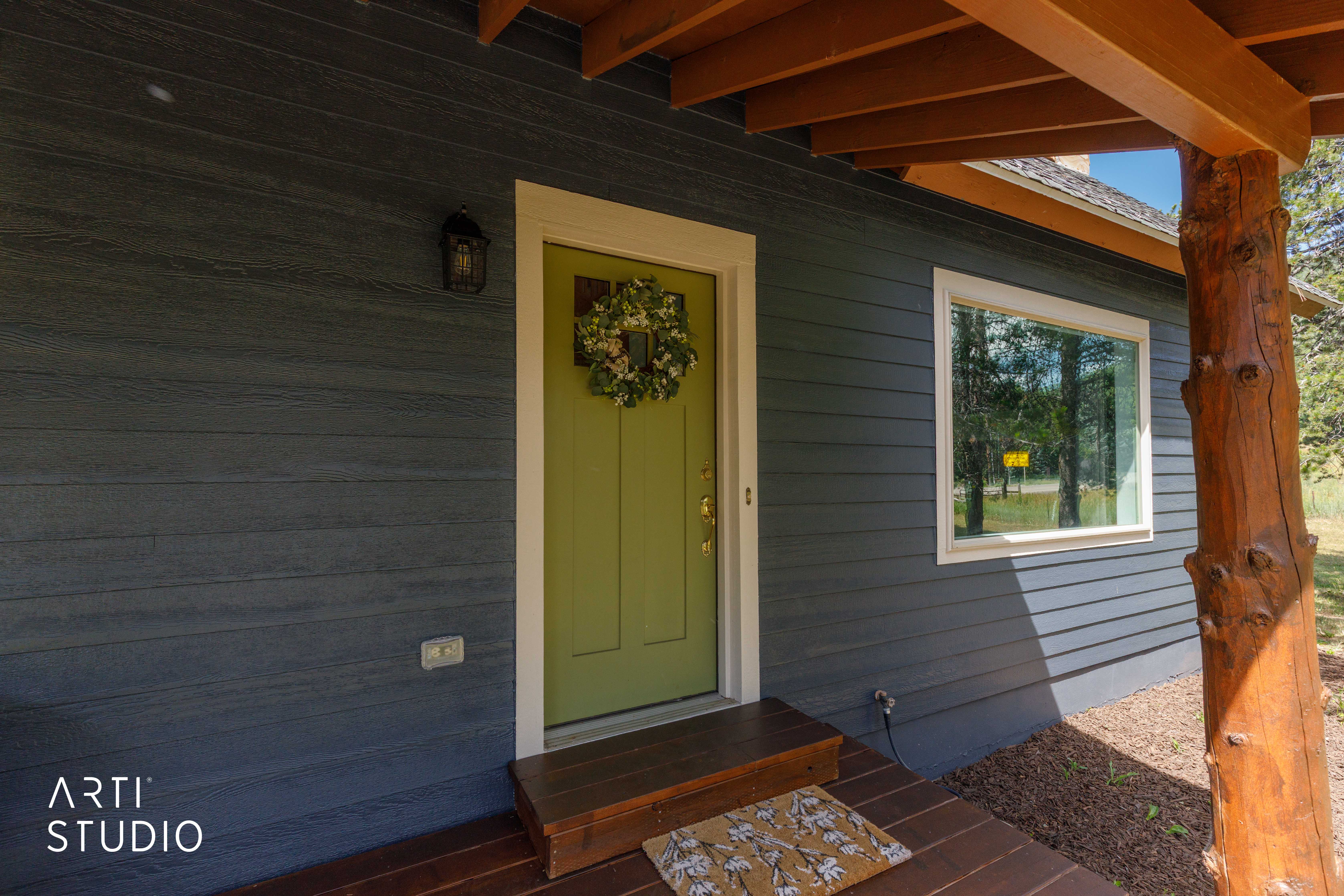 Charcoal-toned horizontal siding with a contrasting lime green entry door