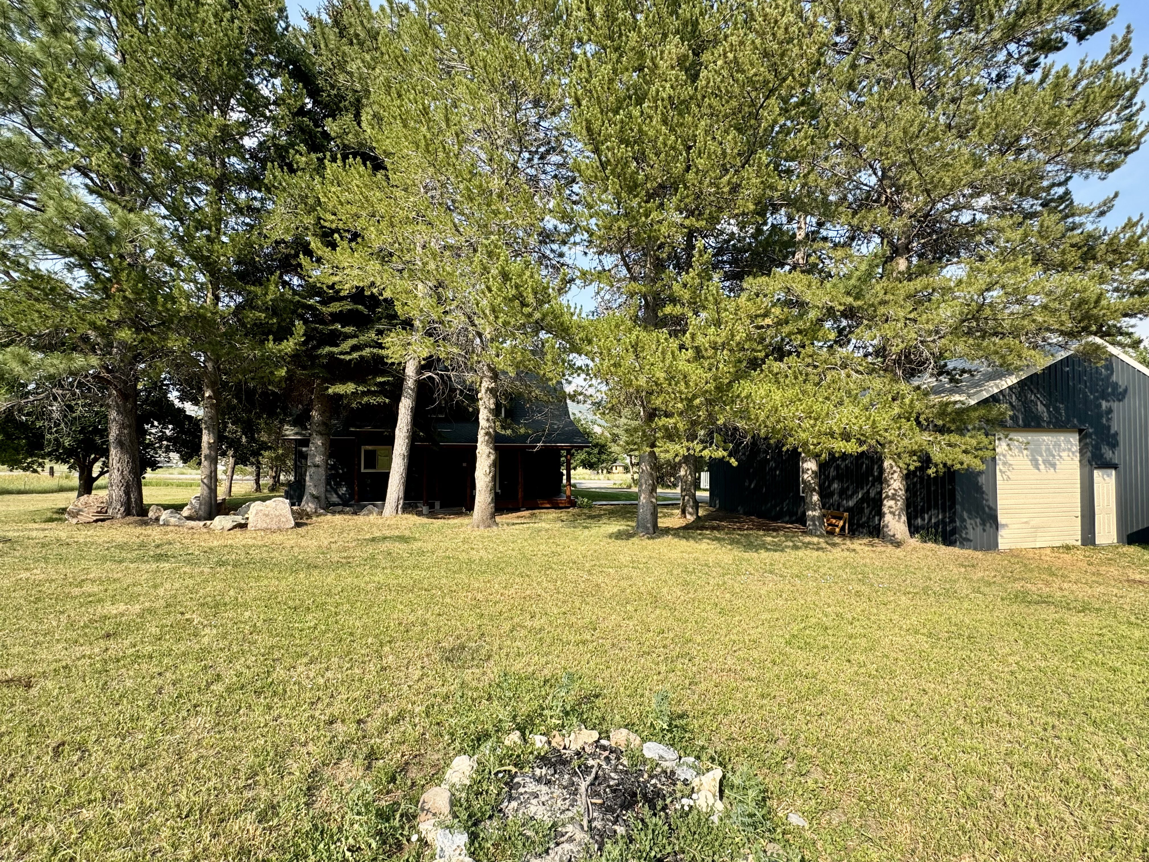 Expansive lawn area featuring a rock-lined fire pit