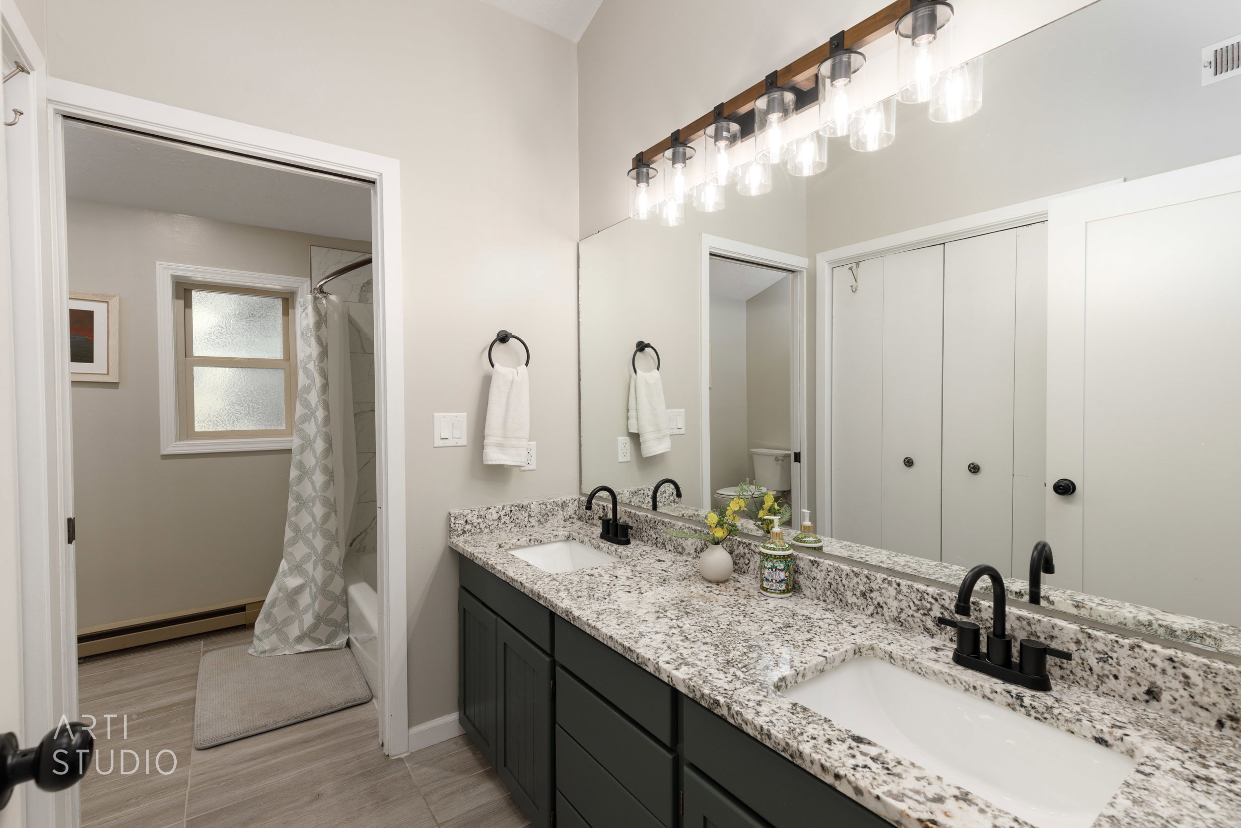 Dual vanity featuring speckled granite countertops and matte black fixtures