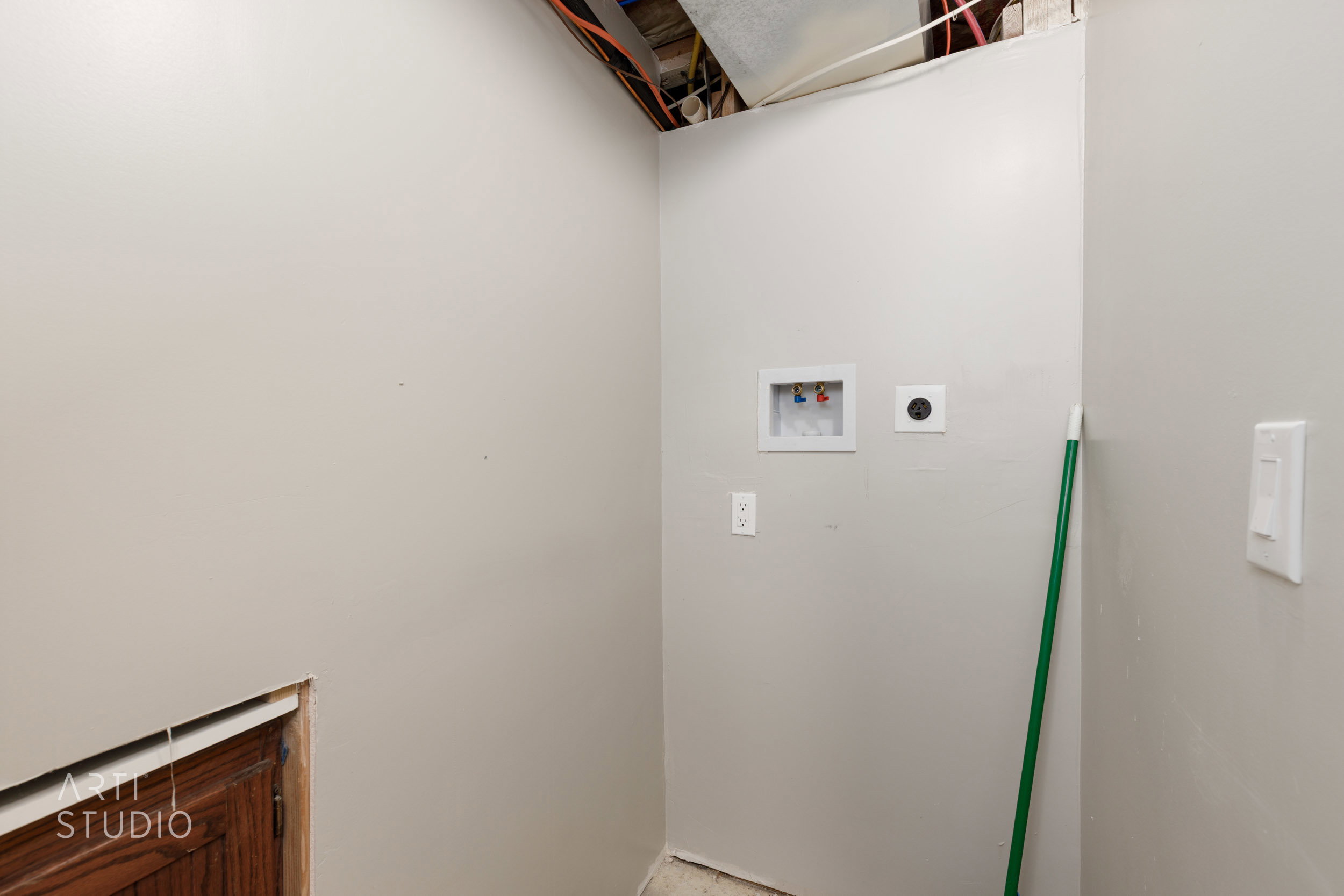 Dedicated laundry area featuring a wall-mounted washer hookup, dryer vent, and light gray painted walls