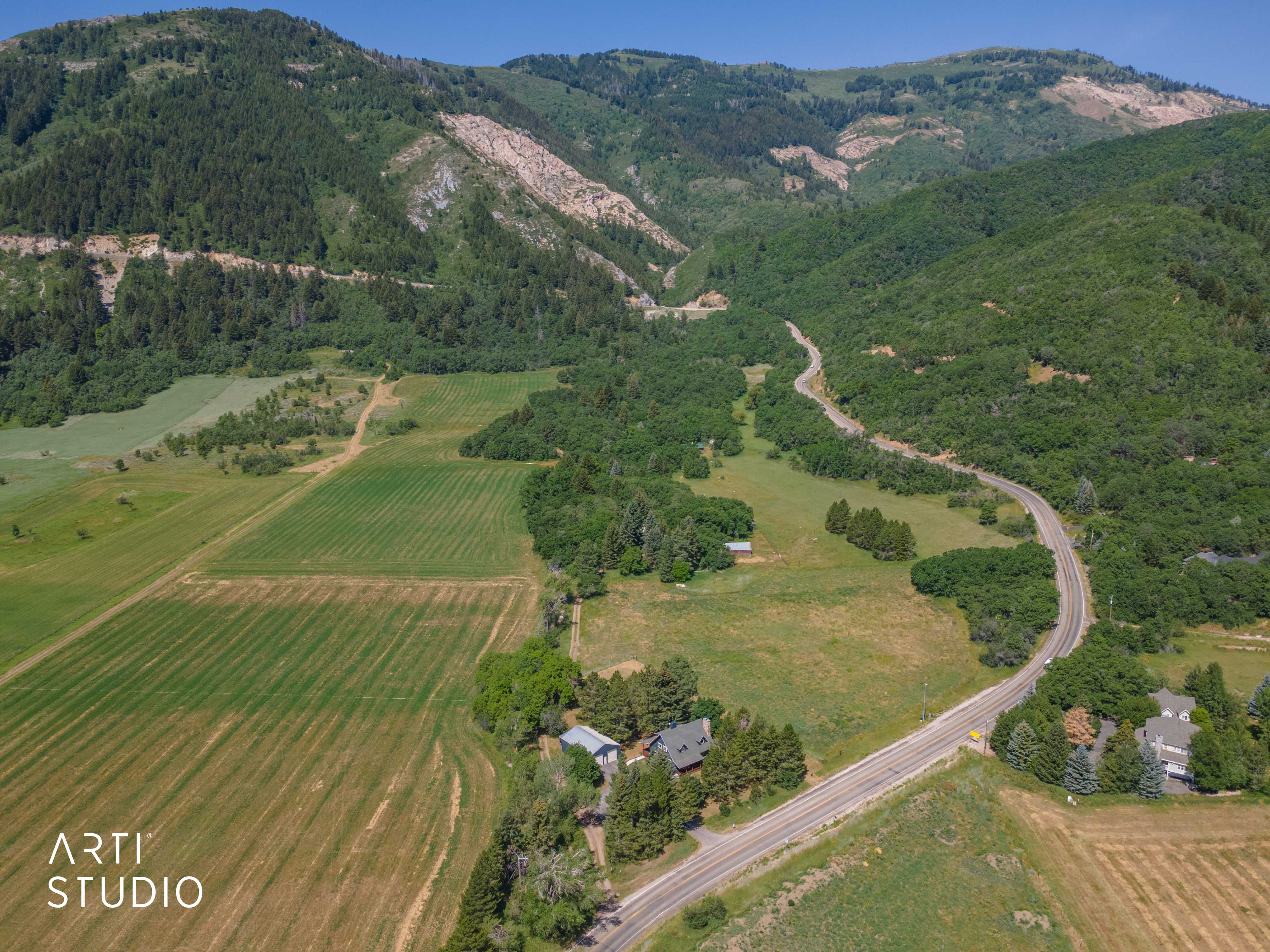 Expansive mountainous landscape featuring lush green foliage and agricultural fields