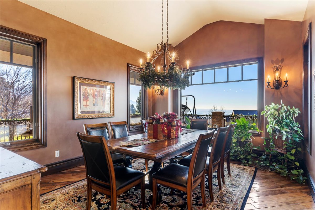 Dining space featuring wide plank wood-finish flooring, a decorative area rug, and an ornate chandelier