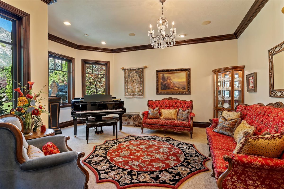 Formal living space featuring light-toned walls, dark wood trim, and crown molding