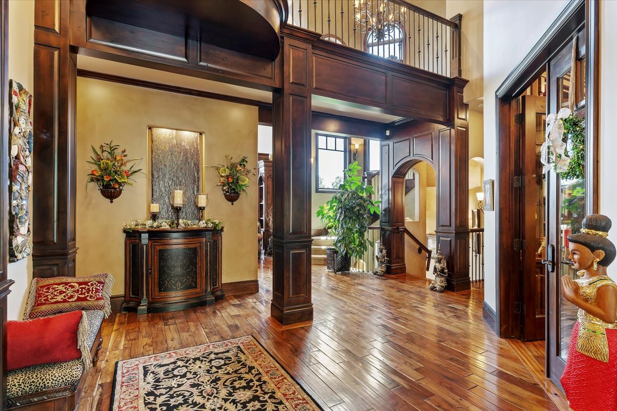 Grand foyer featuring rich wood-finish flooring and extensive wainscoting