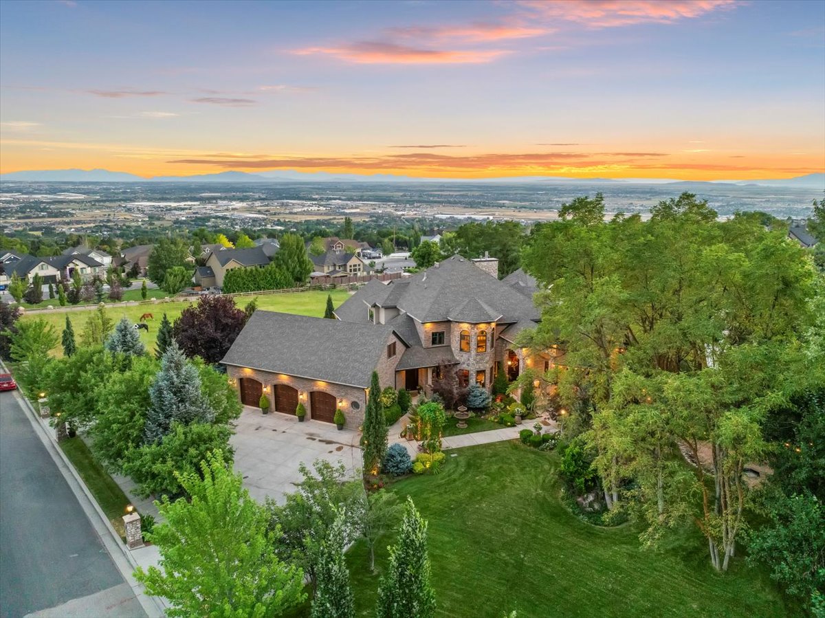 Expansive estate featuring a multi-car garage, mature landscaping, and a substantial lawn area