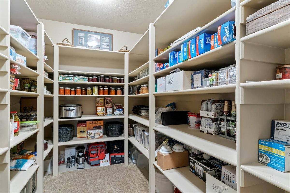 Spacious walk-in pantry featuring extensive built-in shelving, providing ample storage