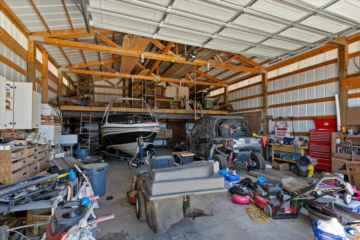 Spacious pole barn structure featuring exposed wood beams and a corrugated metal roof