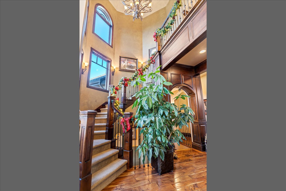 Foyer featuring a grand staircase with carpeted treads and dark wood newel posts