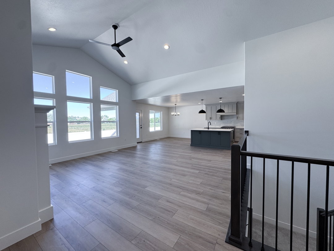 Vaulted ceilings featuring a modern ceiling fan, recessed lighting, and large windows