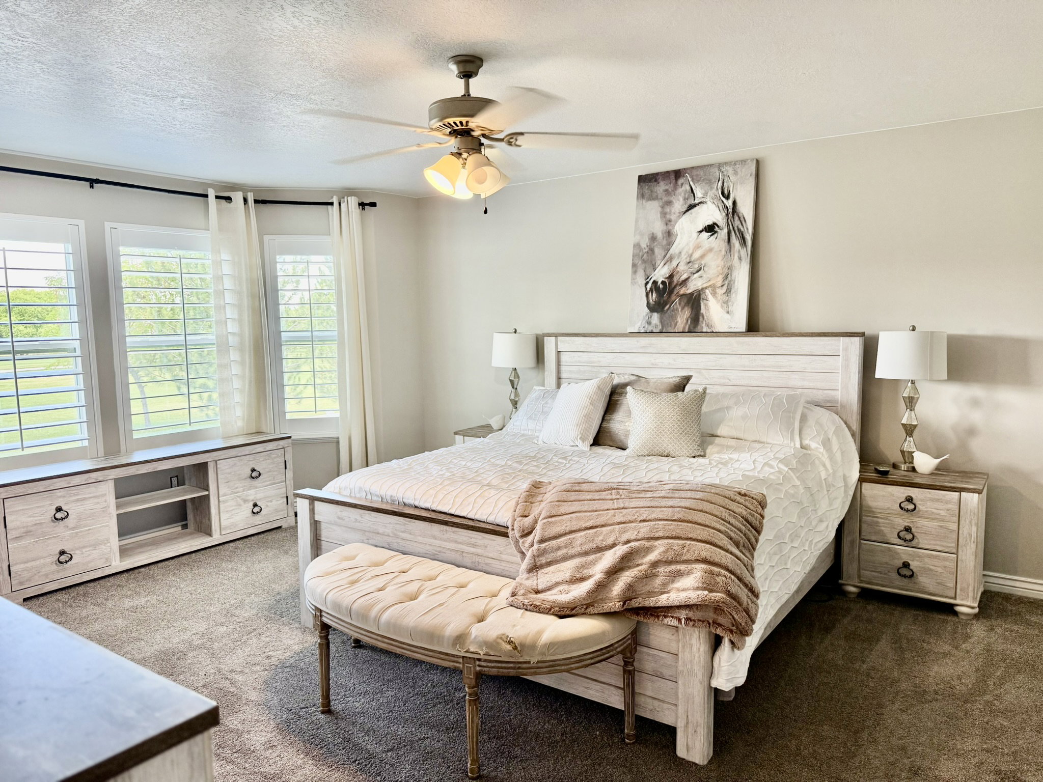 Spacious room featuring carpeting, recessed lighting, a ceiling fan with integrated lighting, and multiple windows with plantation shutters