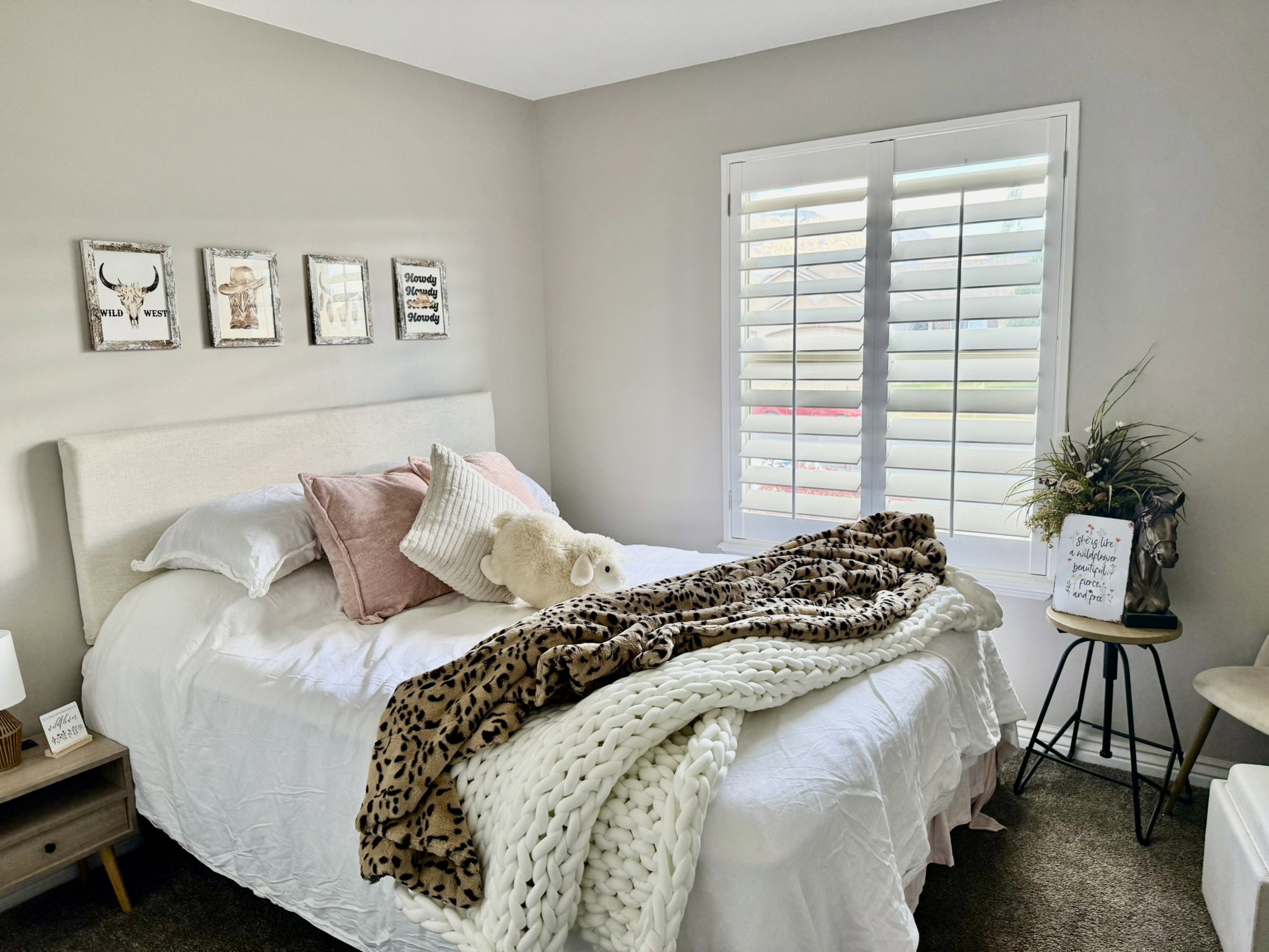 White plantation shutters frame a window, providing controlled natural light
