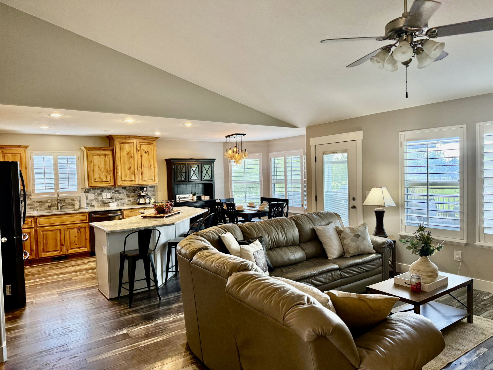 Open-concept living area featuring wood-finish flooring and vaulted ceilings