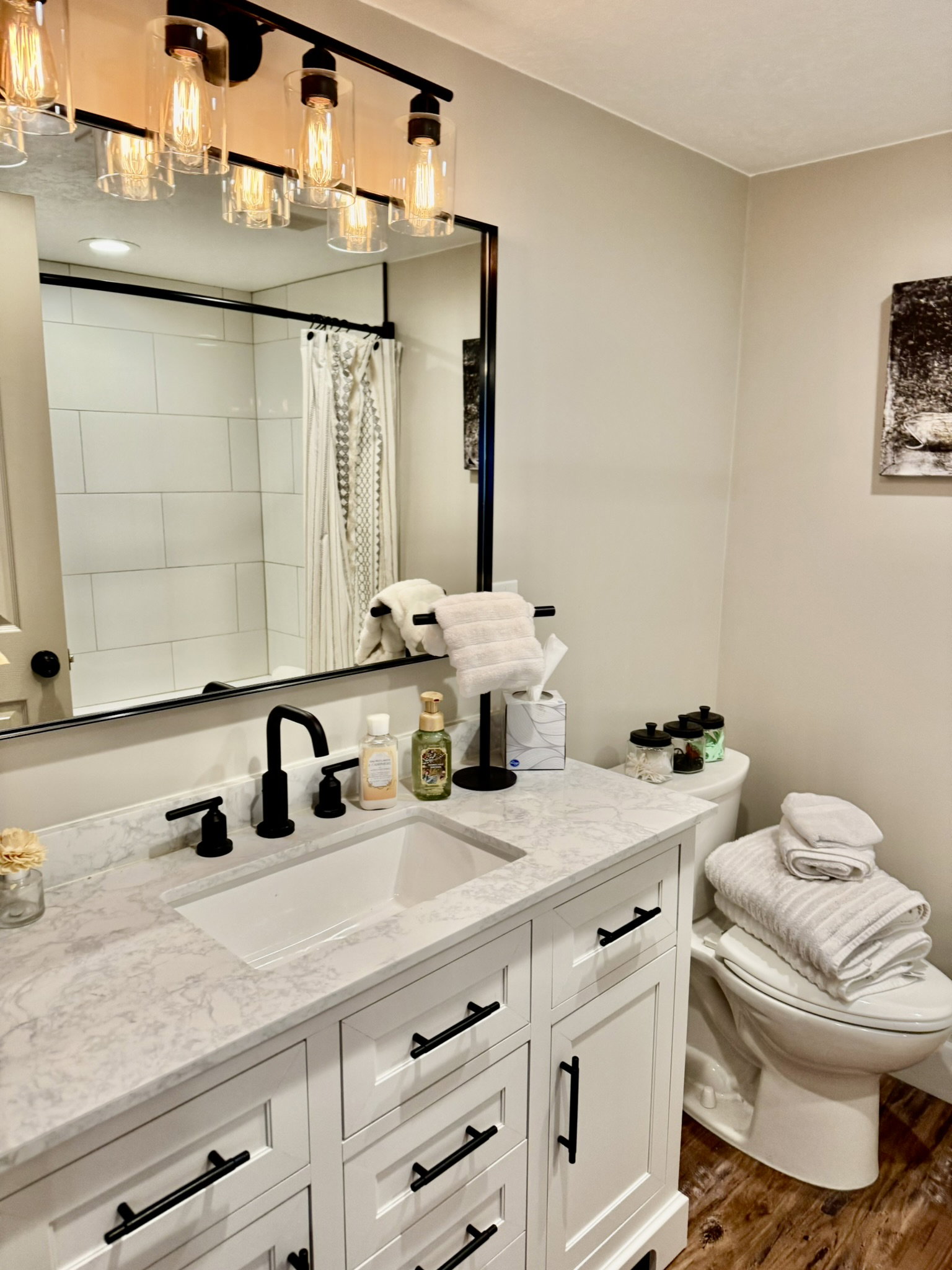 Bathroom featuring a white vanity with black hardware, a light-toned countertop, and a rectangular undermount sink with a matte black faucet